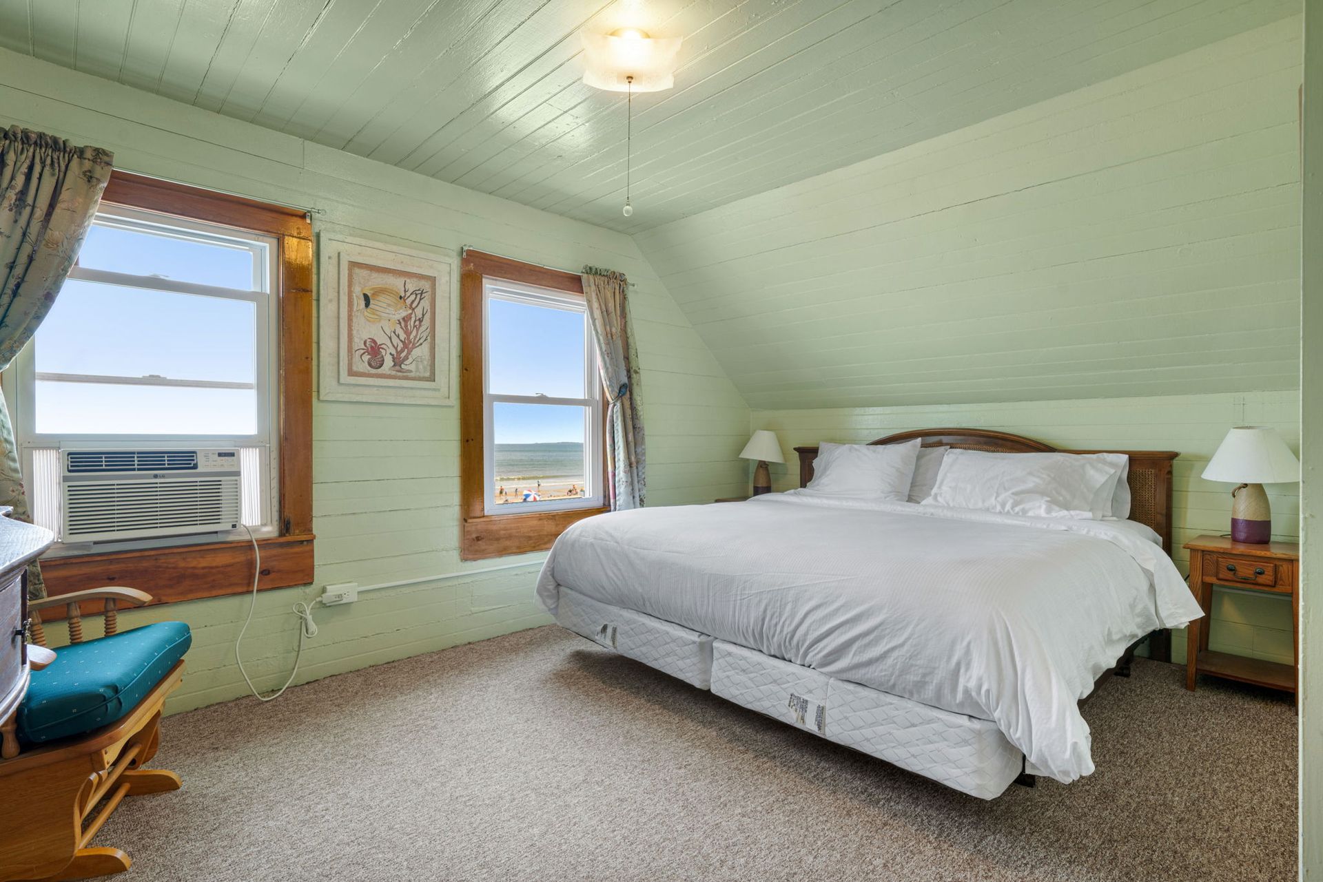 Bedroom with a bed, two windows with a view, green walls, and an air conditioner.
