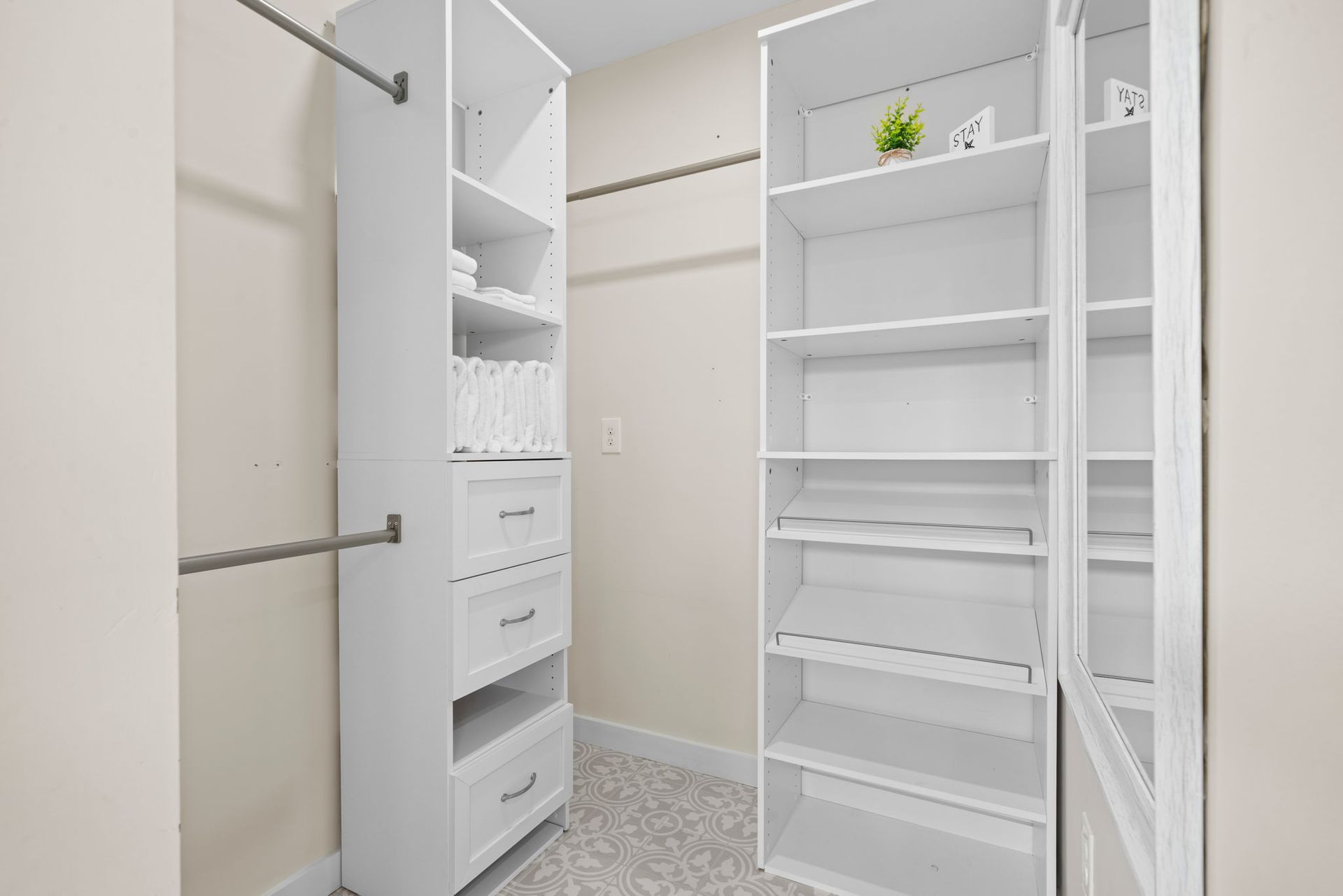 White organized closet with shelves, drawers, and clothing rods.