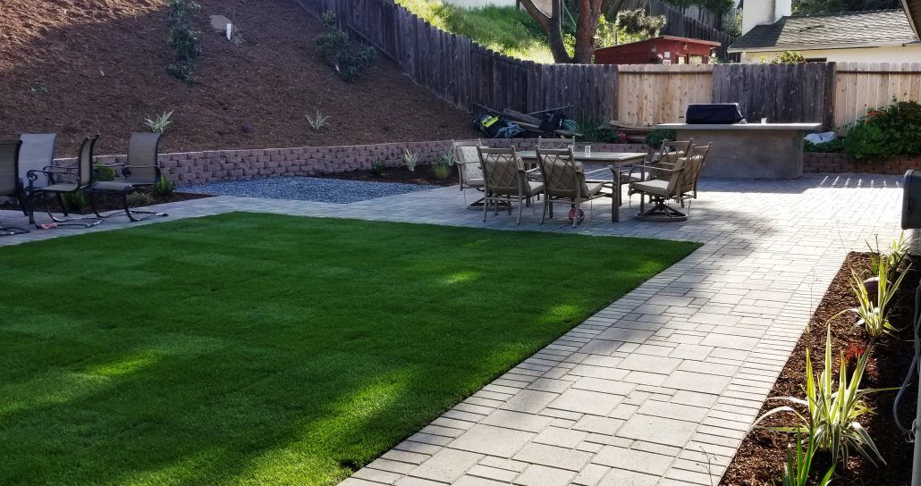 A patio with a table and chairs in the backyard.