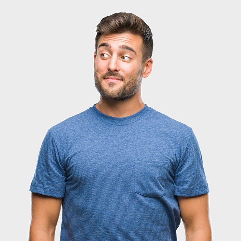 A man in a blue t-shirt is making a funny face.