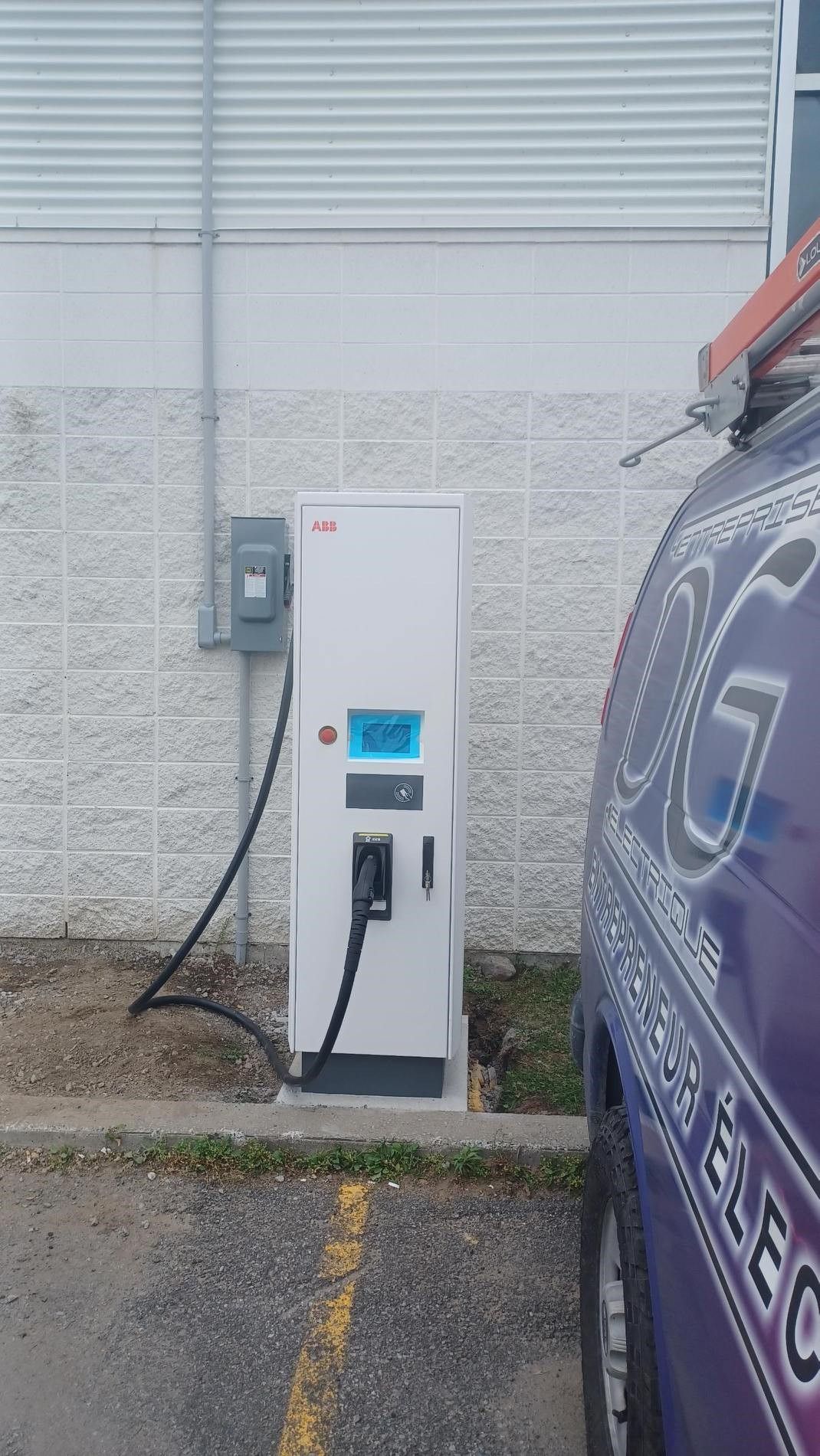 Une voiture est en cours de recharge sur une borne de recharge dans un parking.