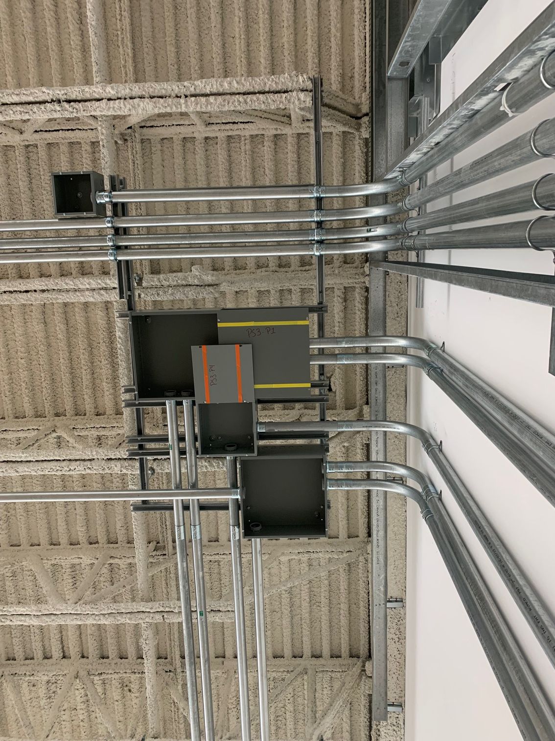 Un tas de tuyaux métalliques pendent du plafond d'un bâtiment.