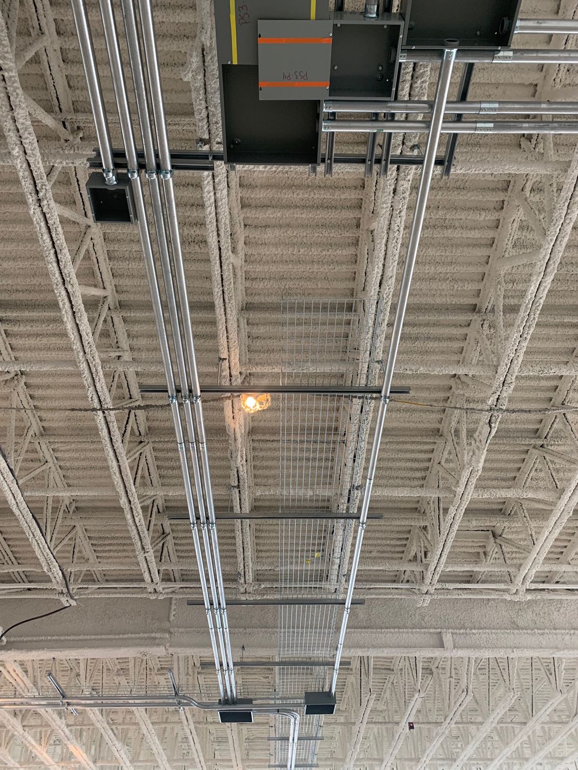 Le plafond d'un bâtiment avec beaucoup de fils qui y pendent.