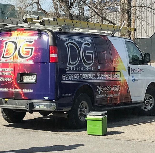 Une camionnette violette et blanche avec le mot dg à l'arrière