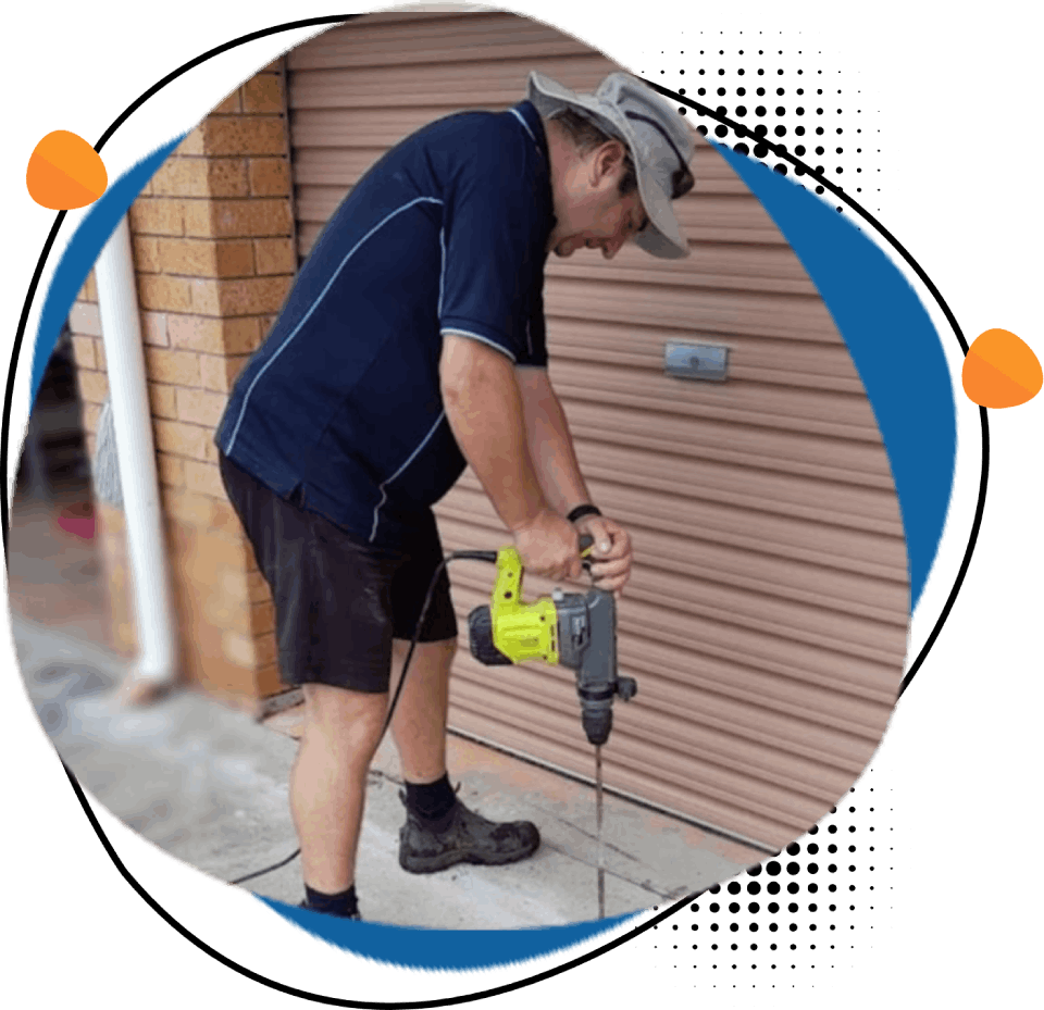 A man is using a drill to drill a hole in a wall.