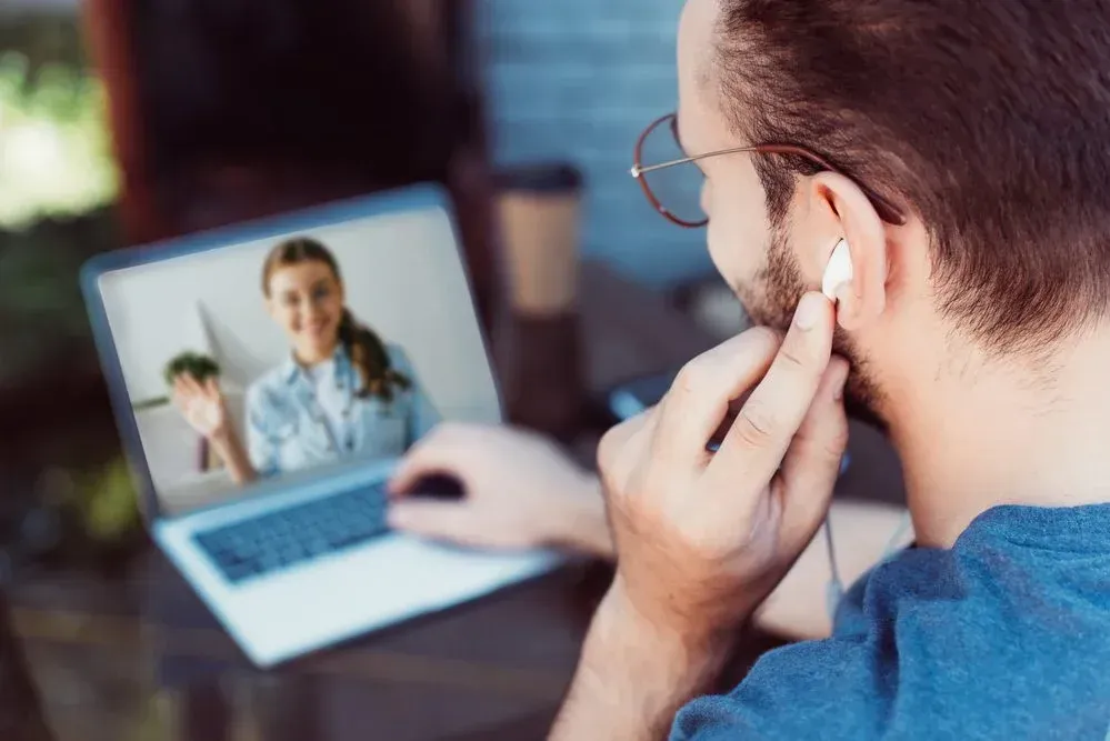 A man is having a video call with a doctor on his laptop.