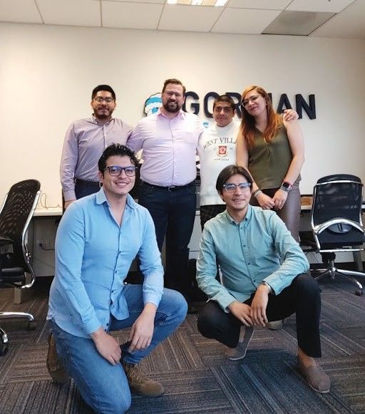 A group of people posing for a picture in front of a sign that says gorman