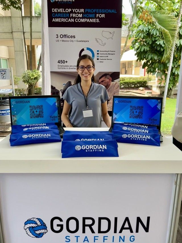 A woman is standing in front of a gordian staffing booth