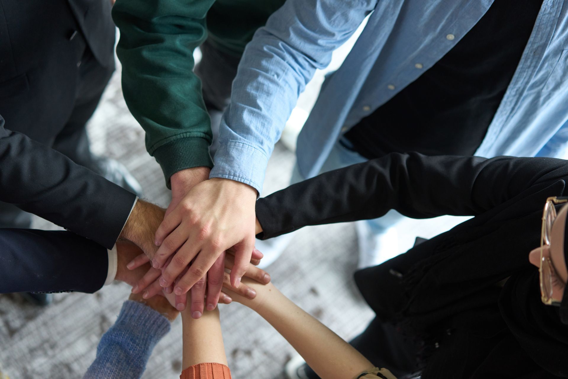 A group of people are putting their hands together.