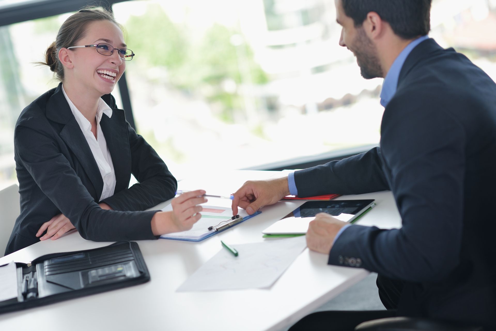 A man and a woman are sitting at a table having a conversation.