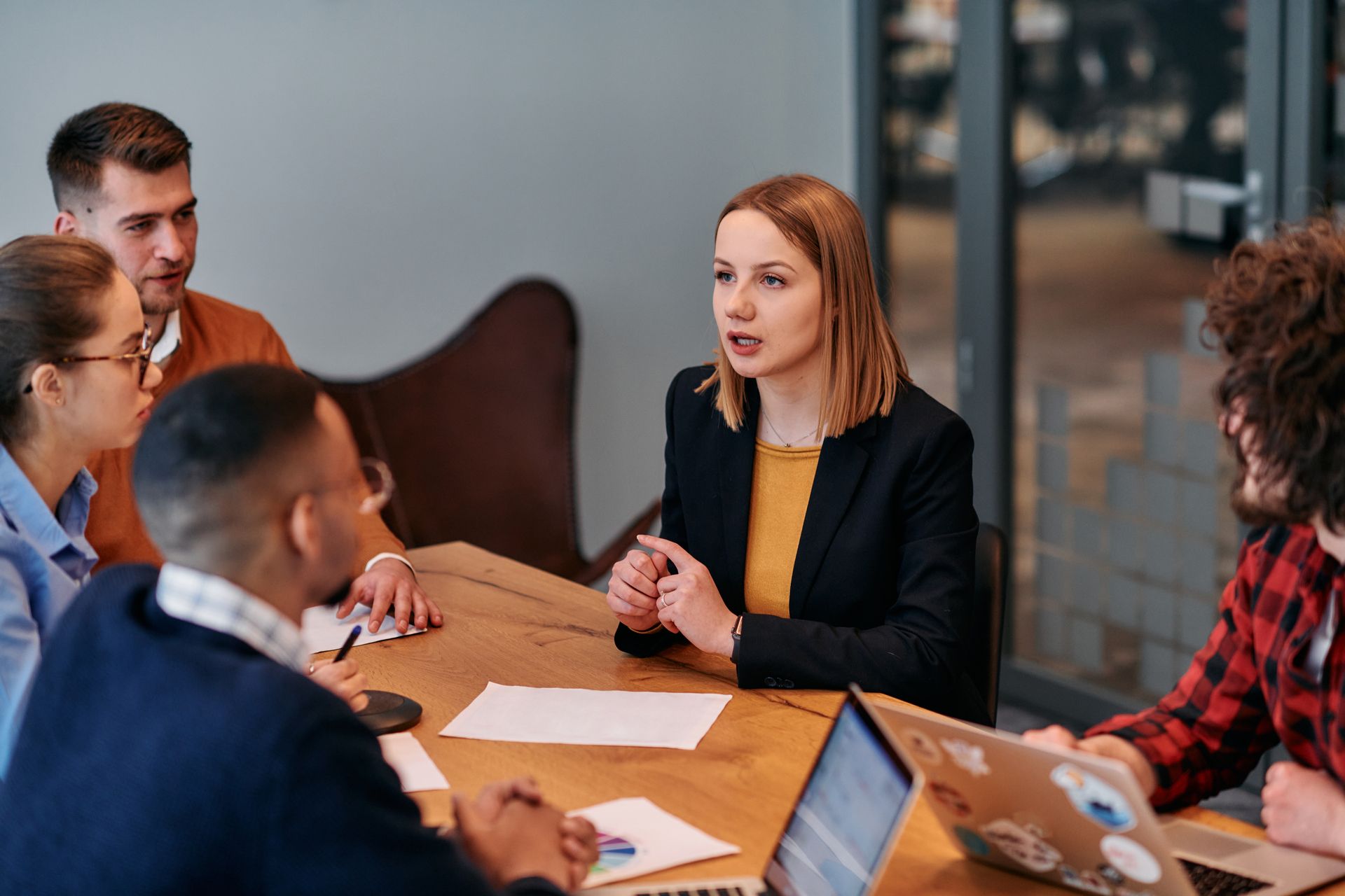 A group of people are sitting around a table having a meeting.