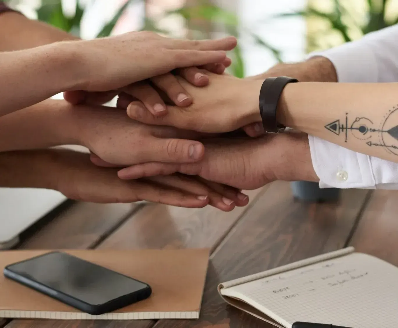 A group of people stacking their hands on top of each other