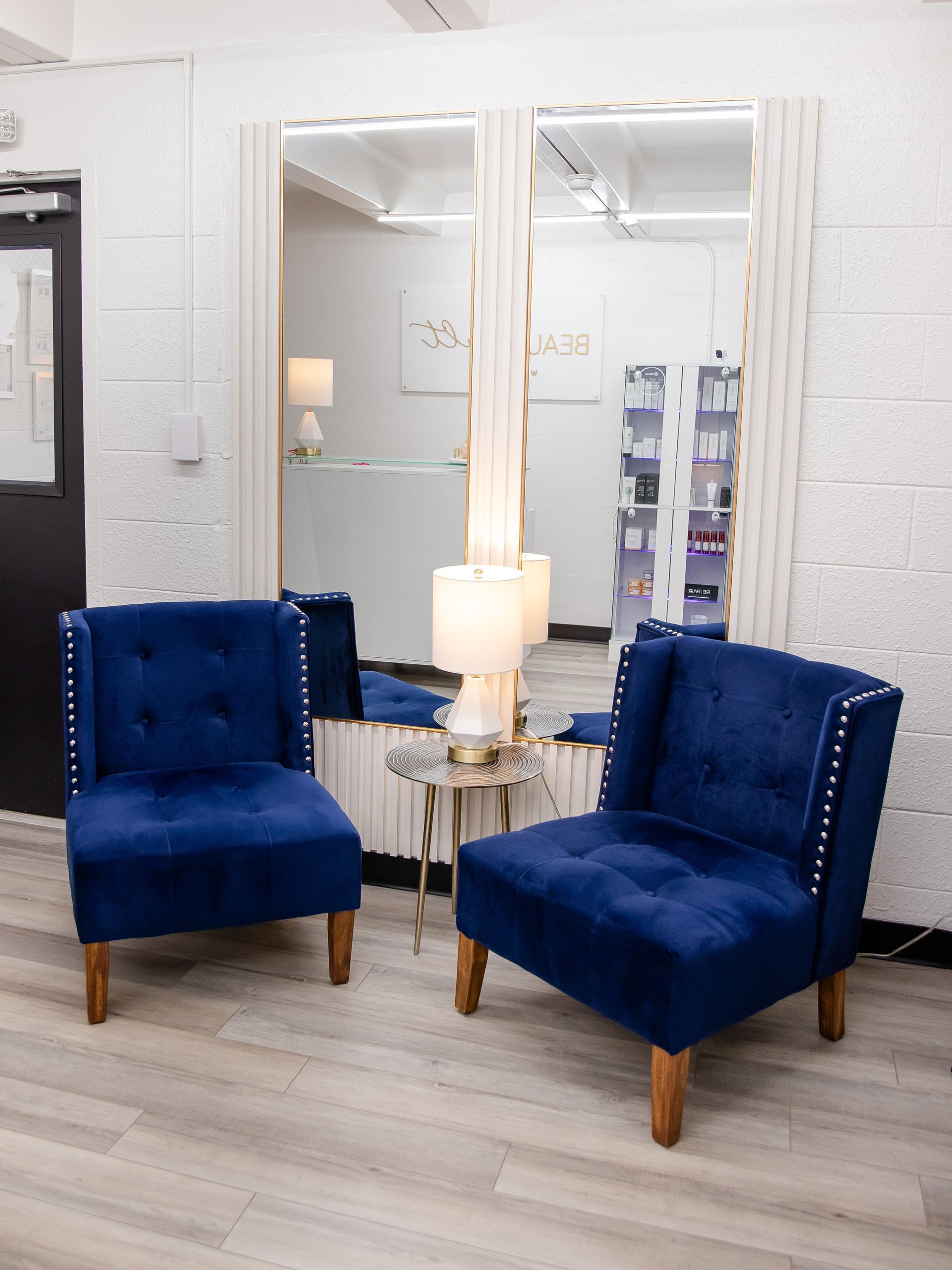 Two blue chairs are sitting in front of a mirror in a room.