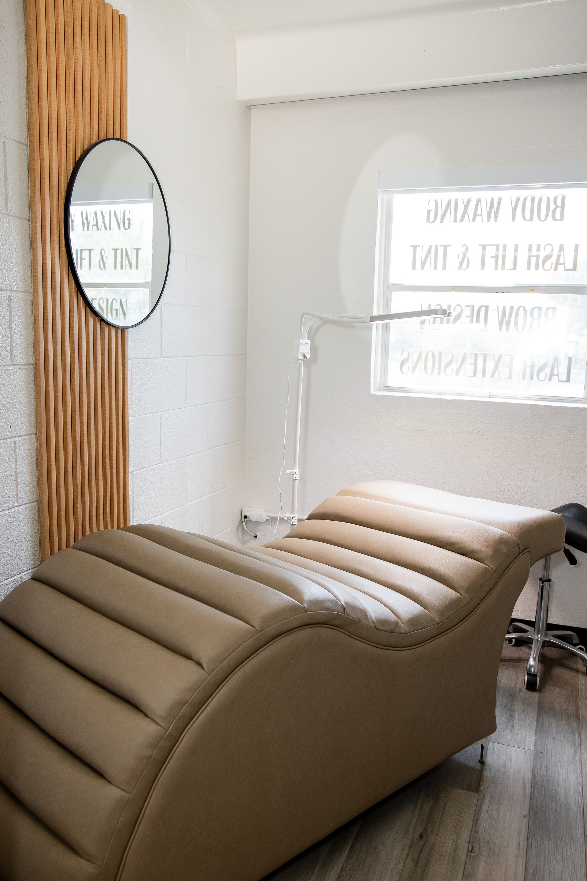 A chair is sitting in a room next to a mirror.