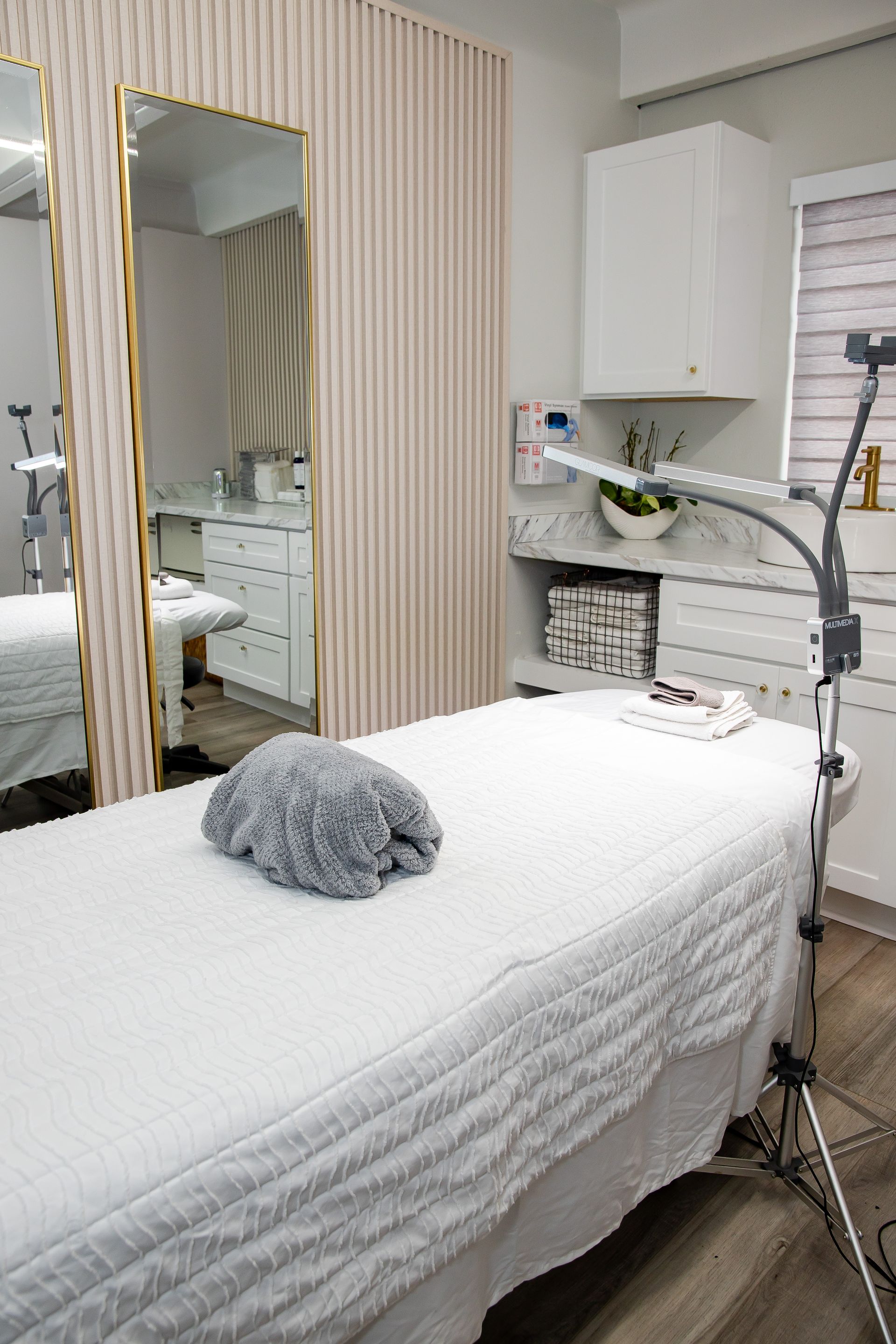 There is a bed with a towel on it in a room with a mirror.