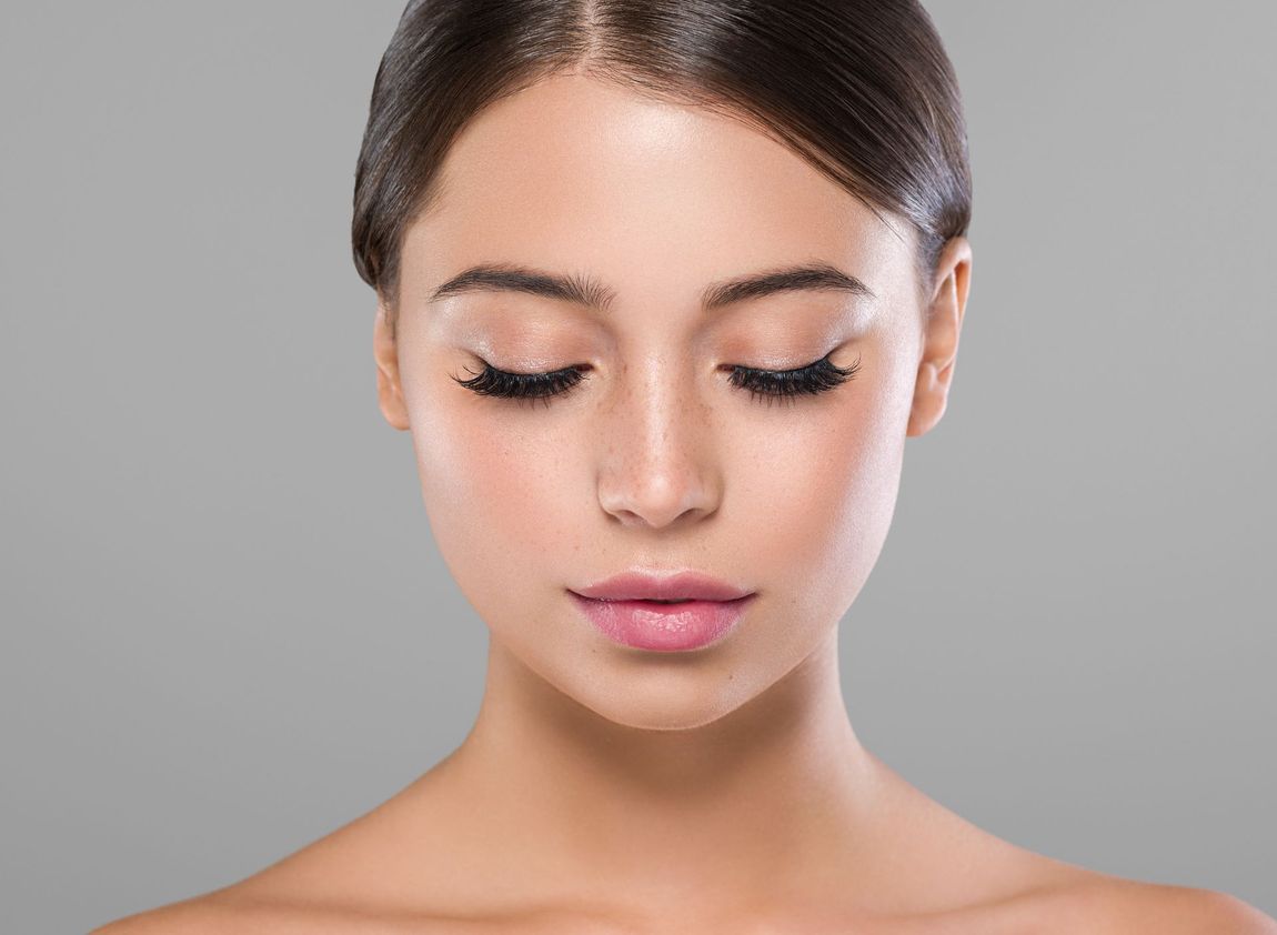 A close up of a woman 's face with her eyes closed.