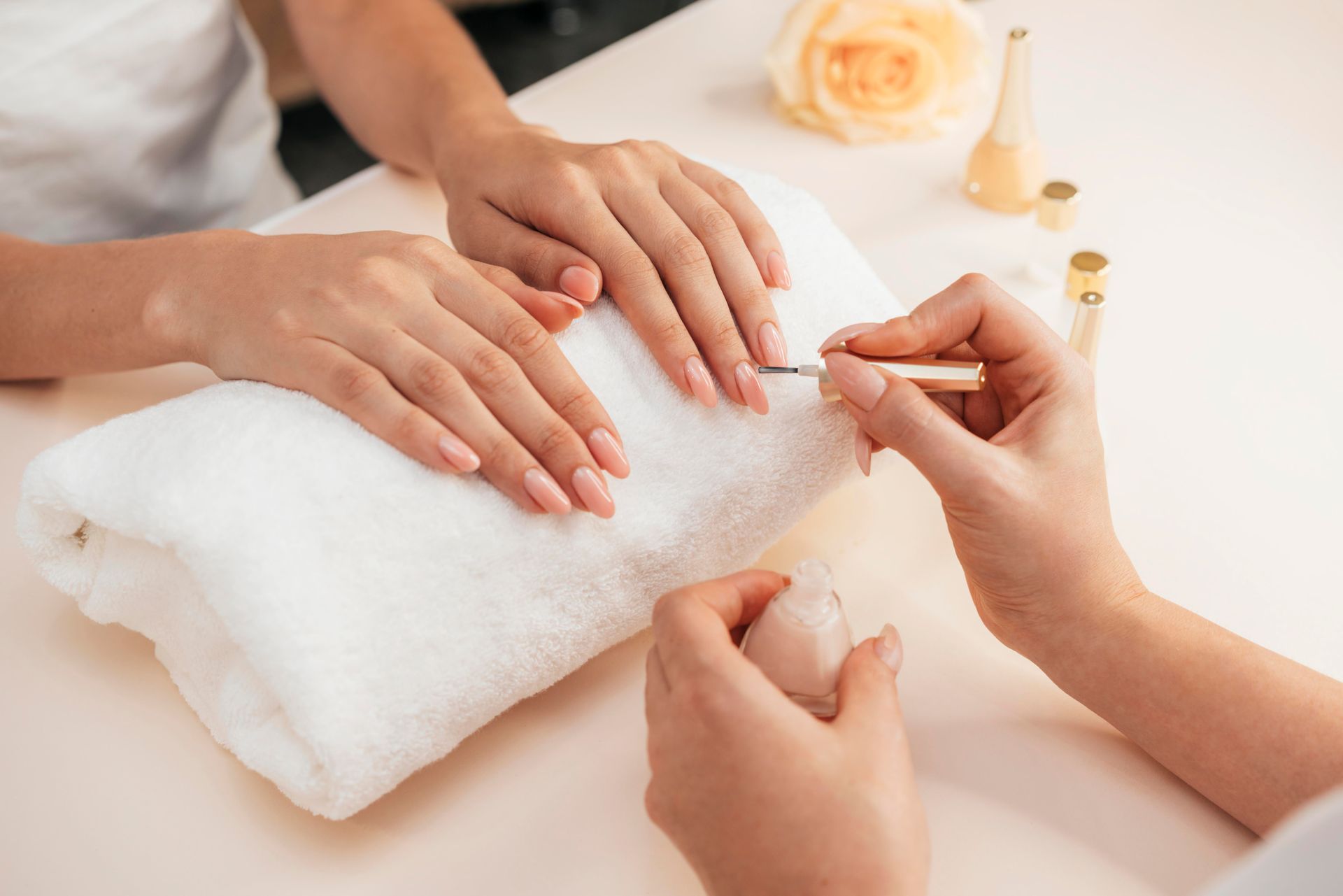 A woman is getting her nails painted at a nail salon.