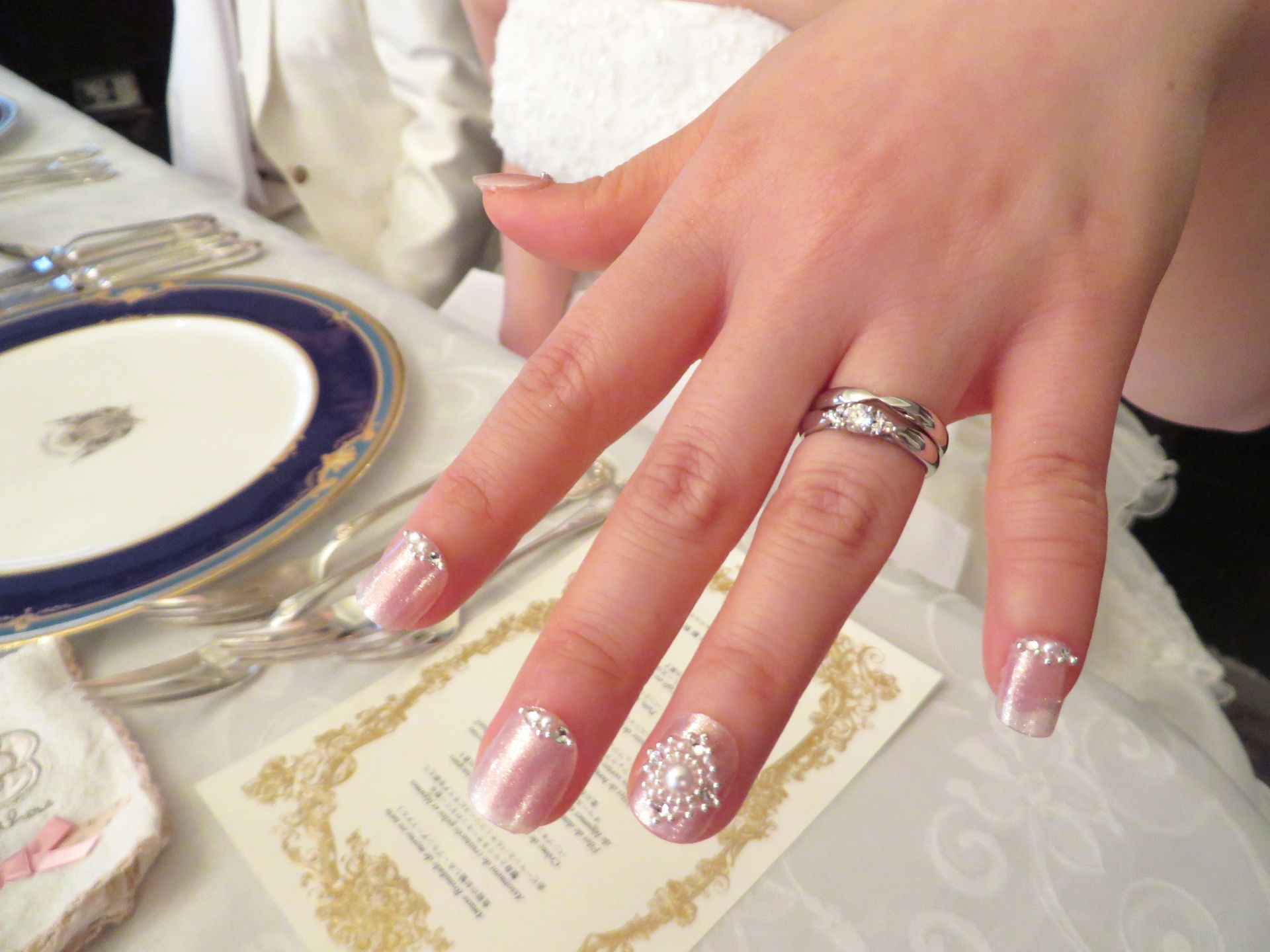 A woman 's hand with a wedding ring on it
