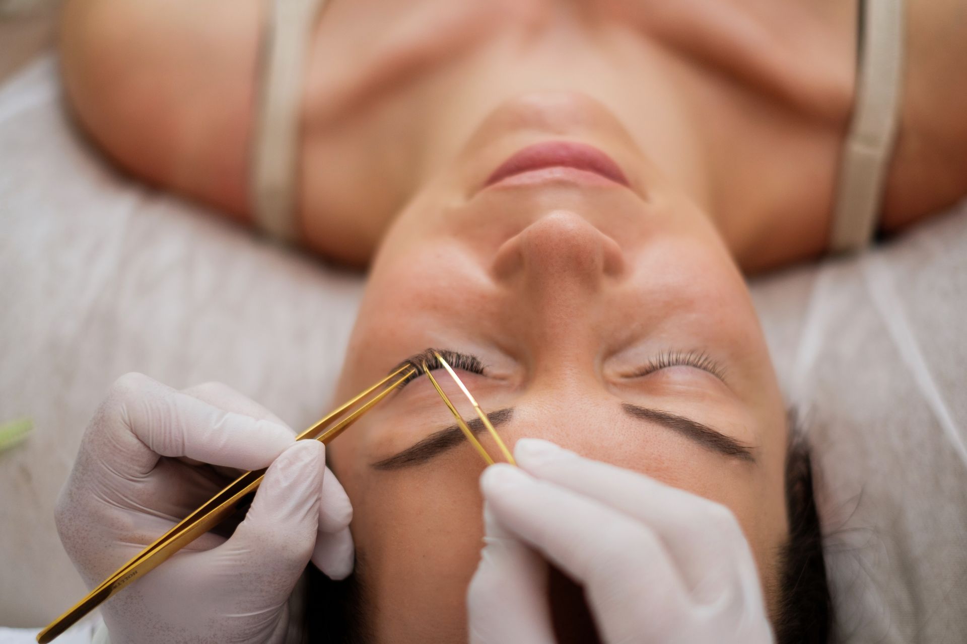 A woman is getting her eyebrows done at a beauty salon.