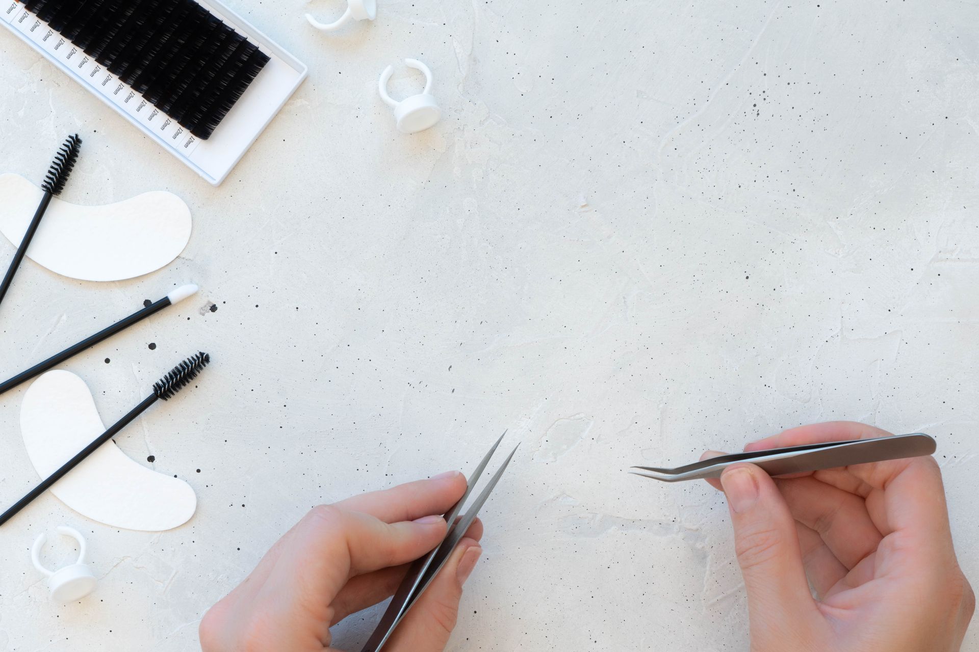 A person is holding a pair of tweezers in their hands.