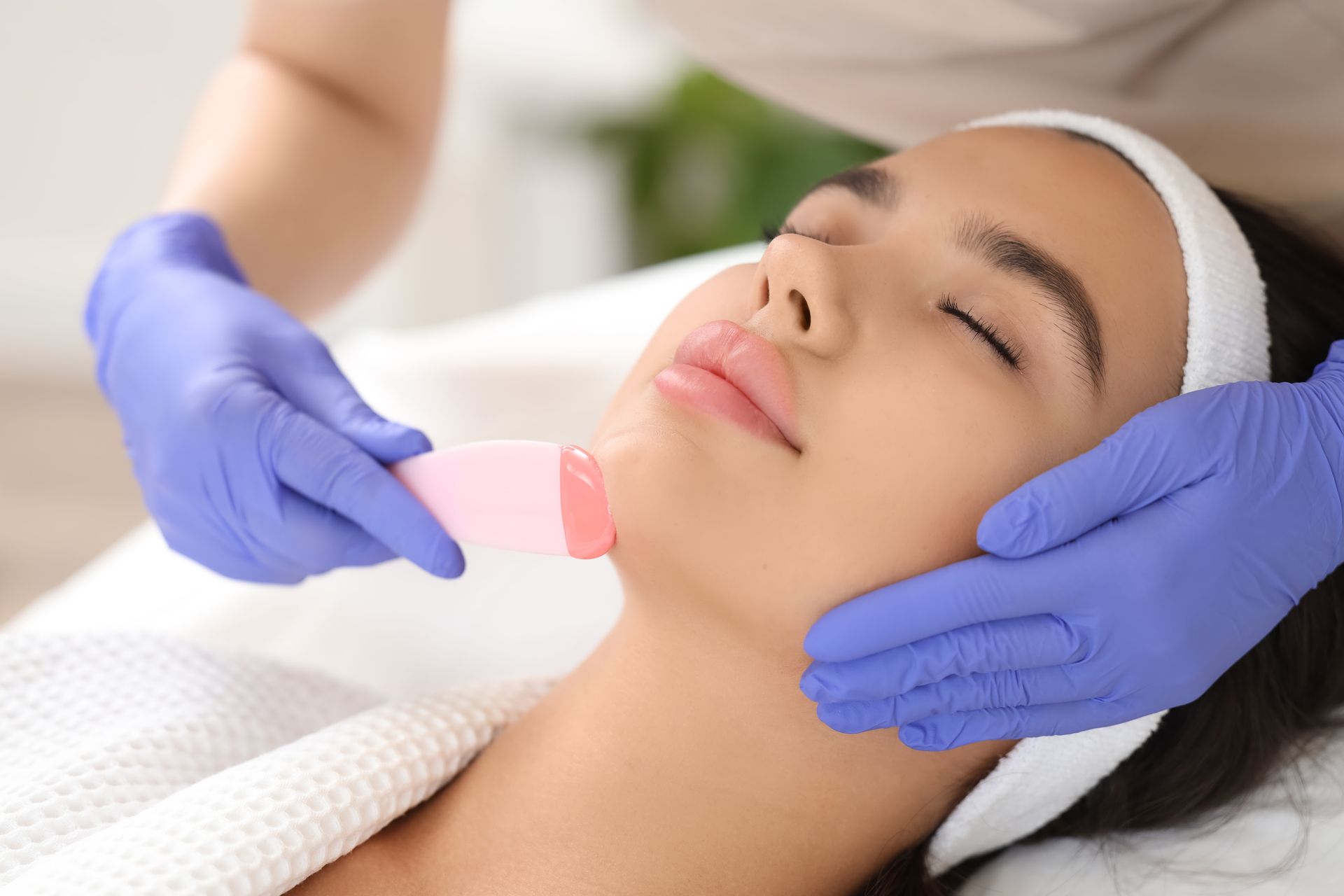 A woman is getting a facial treatment at a beauty salon.