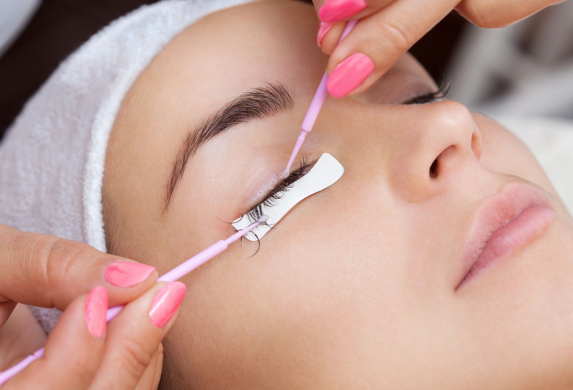 A woman is getting her eyelashes done at a beauty salon.