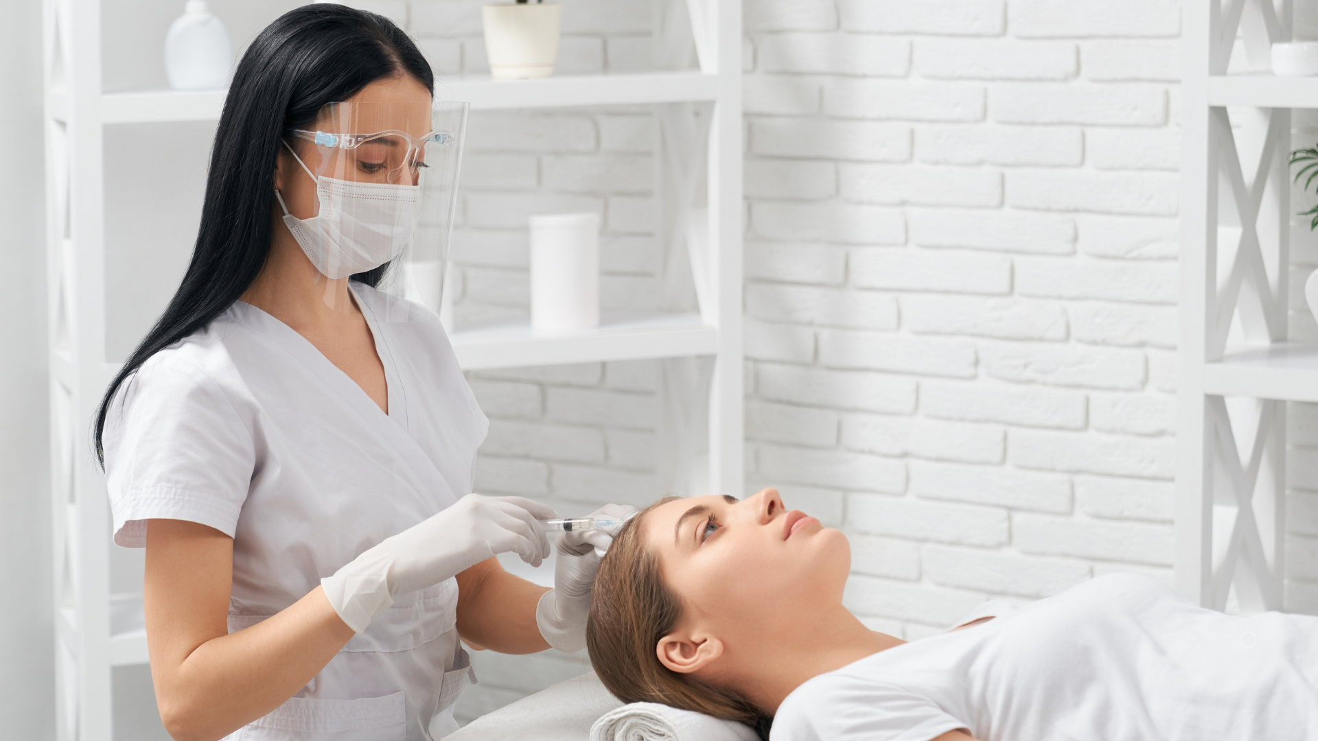 A woman is getting an injection in her head at a beauty salon.