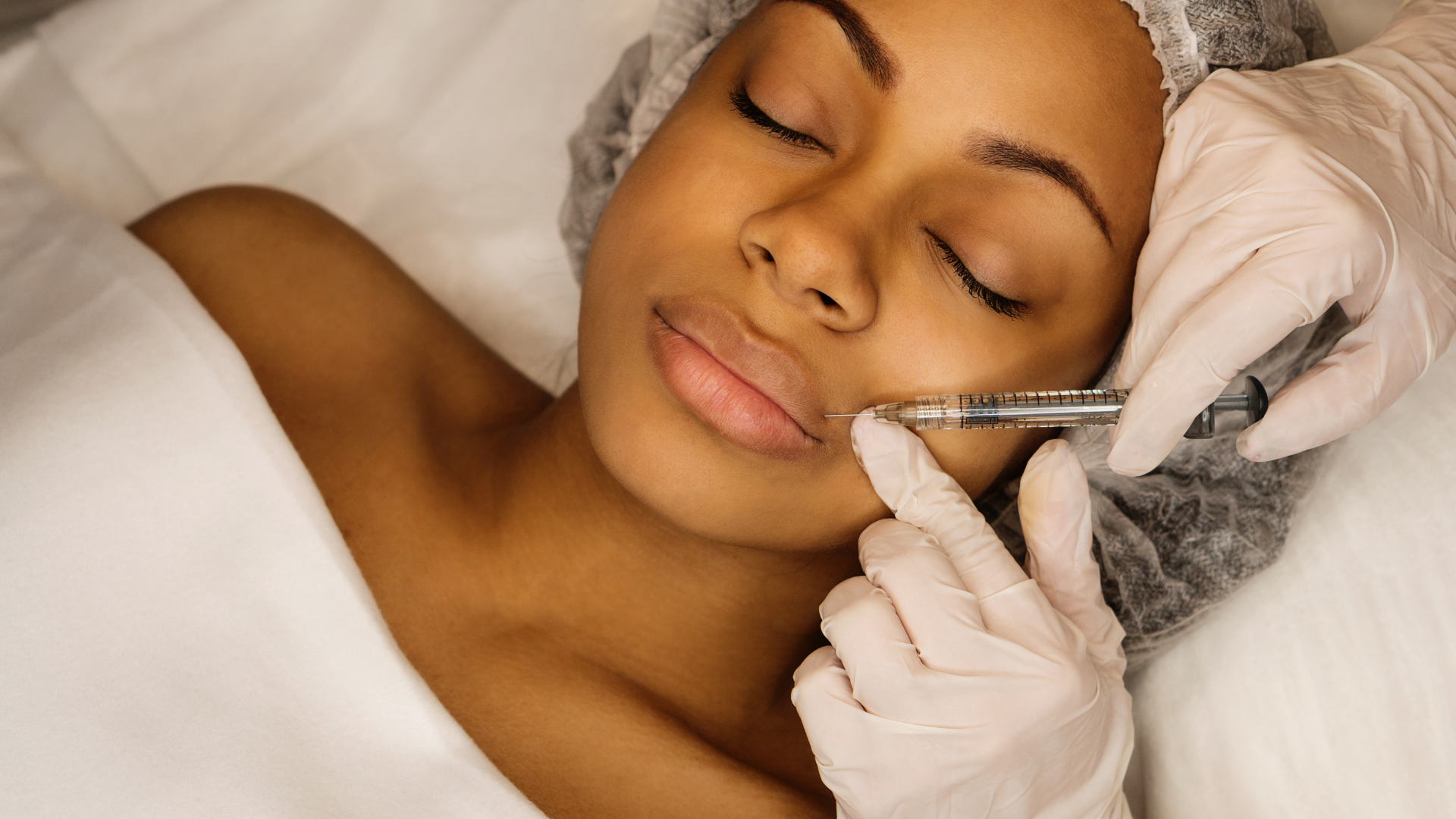 A woman is getting a botox injection in her face.