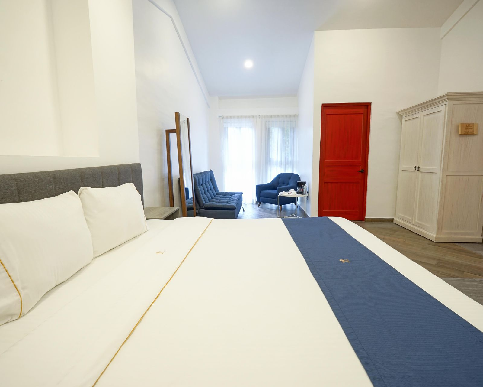 Dormitorio con una cama, dos mesitas de noche y una pared.