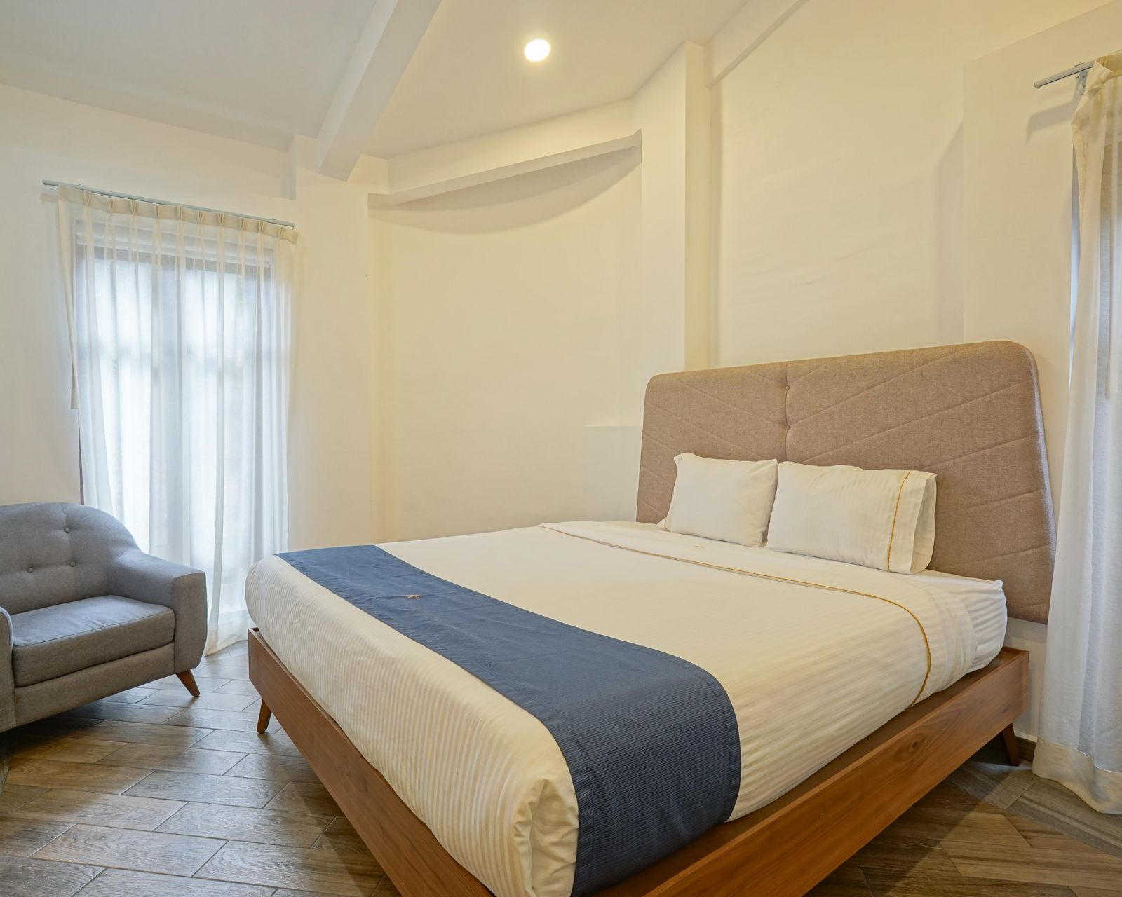 Dormitorio con cama, mesita de noche y puerta abierta a balcón.