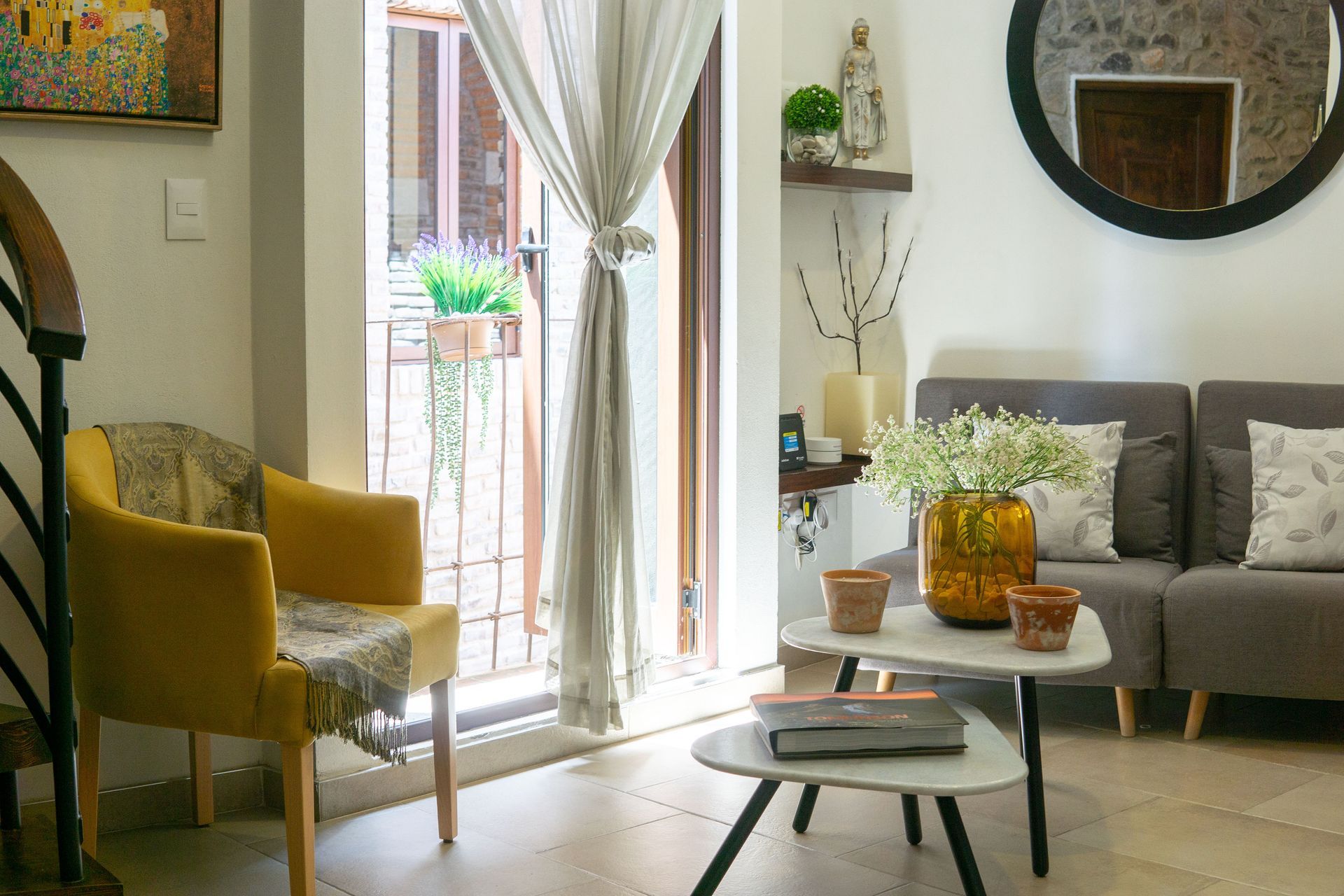 Acogedora sala de estar con sofás grises, chimenea de piedra, detalles de madera y una estantería llena de libros.