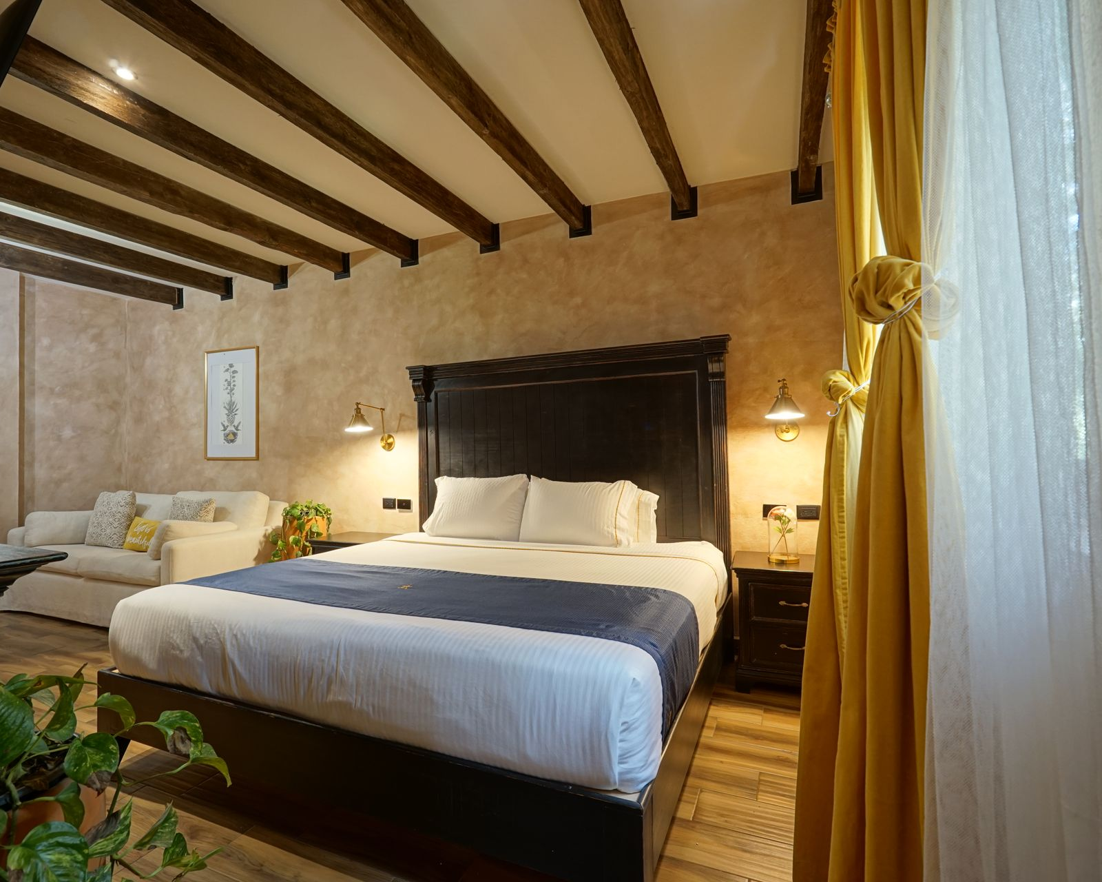 Dormitorio con cama roja, ropa de cama azul, dos mesitas de noche y pared texturizada de color bronce.