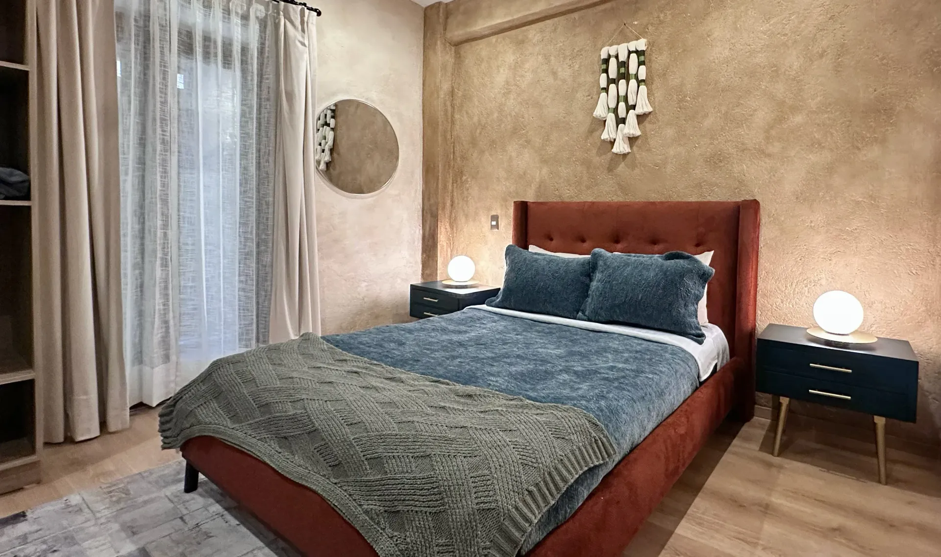 Bedroom with a red bed, blue bedding, nightstands, and decorative wall art.