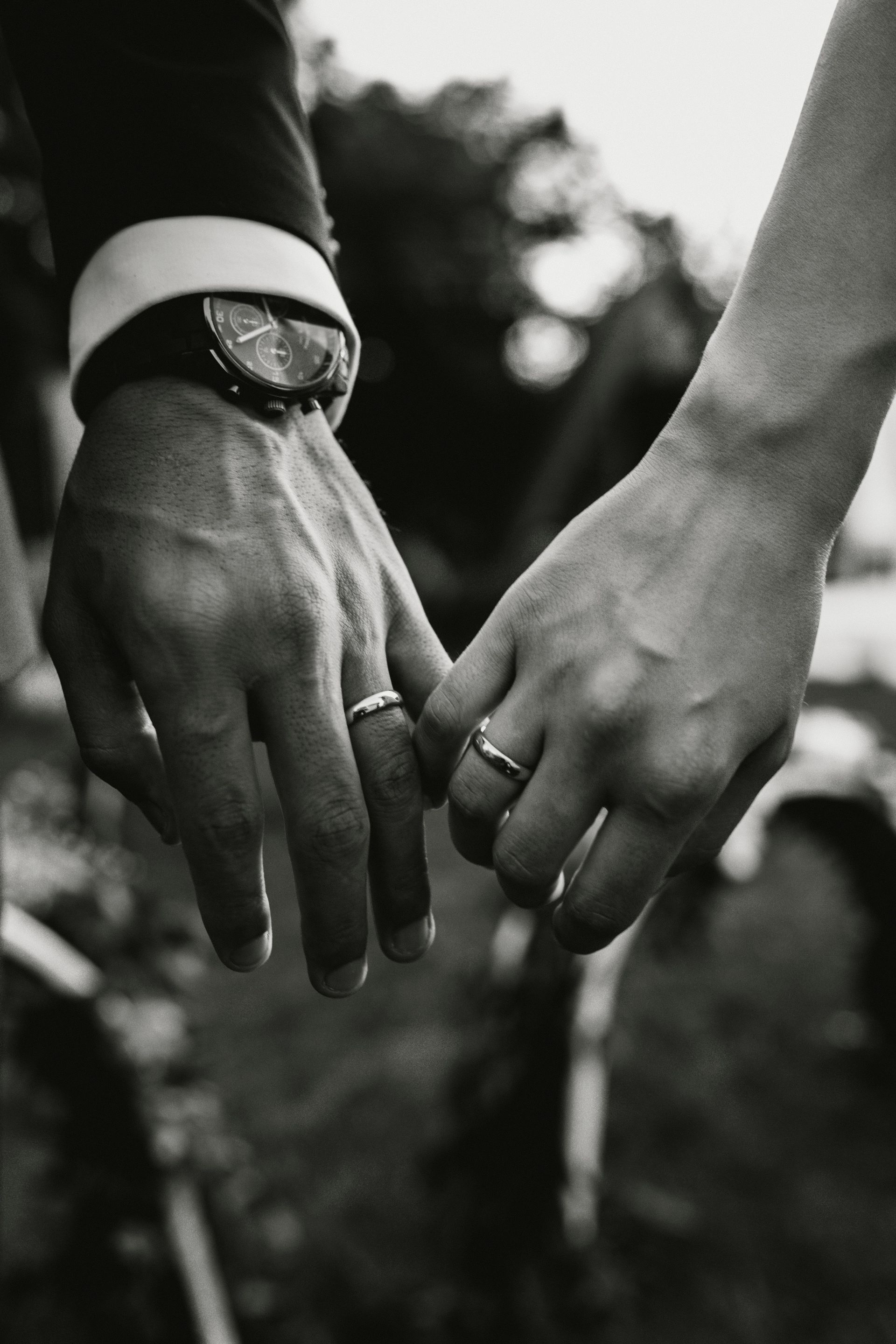 Una fotografía en blanco y negro de una novia y un novio tomados de la mano.