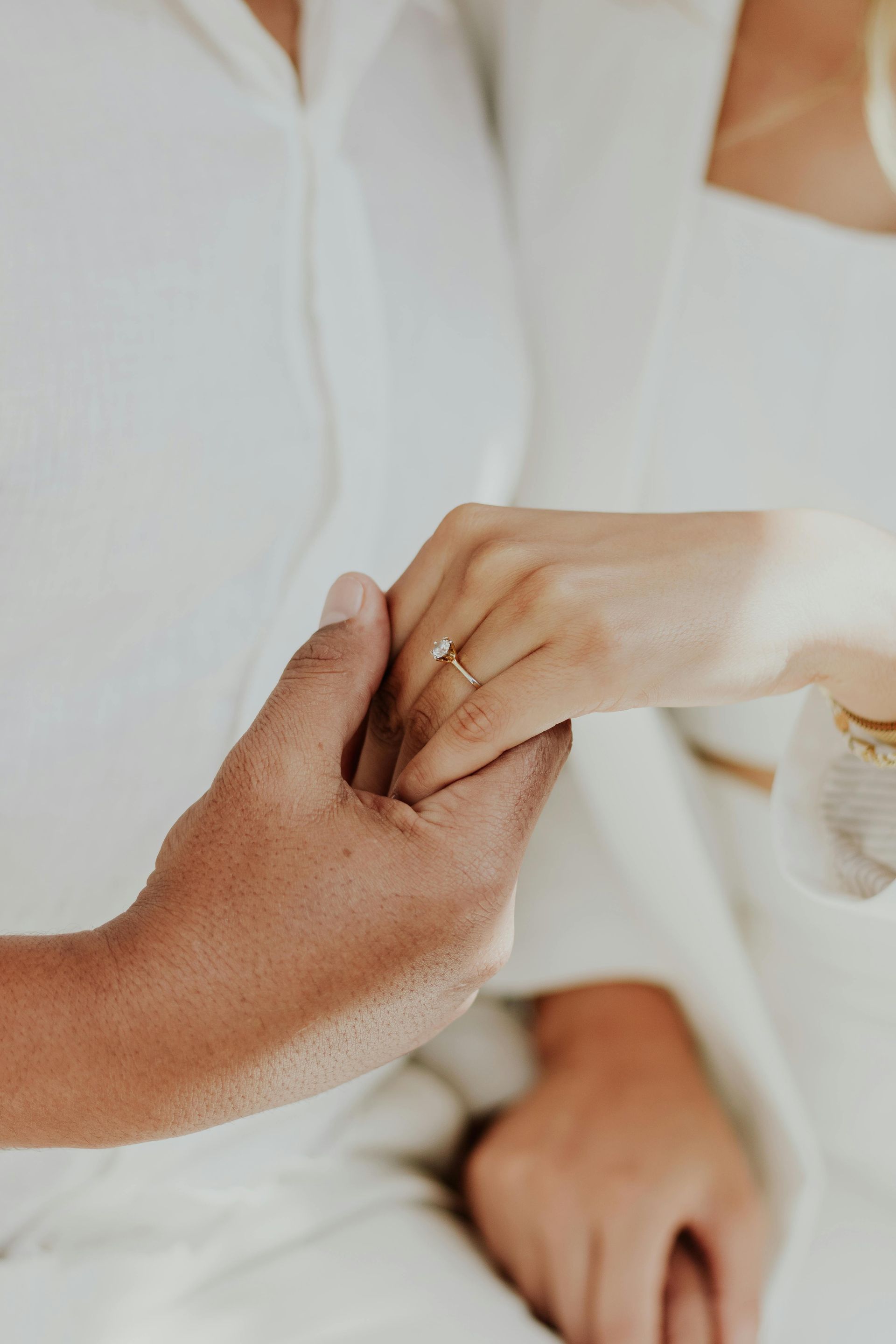 Un hombre está poniendo un anillo de compromiso en el dedo de una mujer.