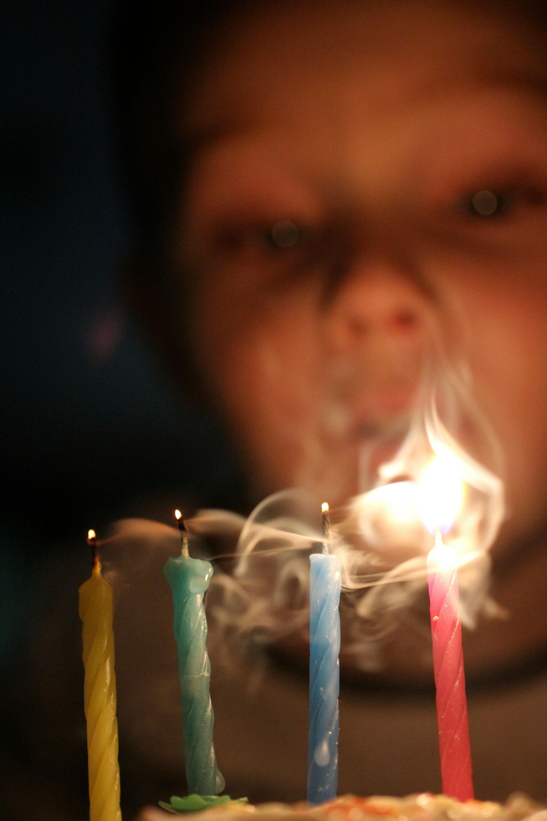 Una persona está soplando las velas de un pastel de cumpleaños.