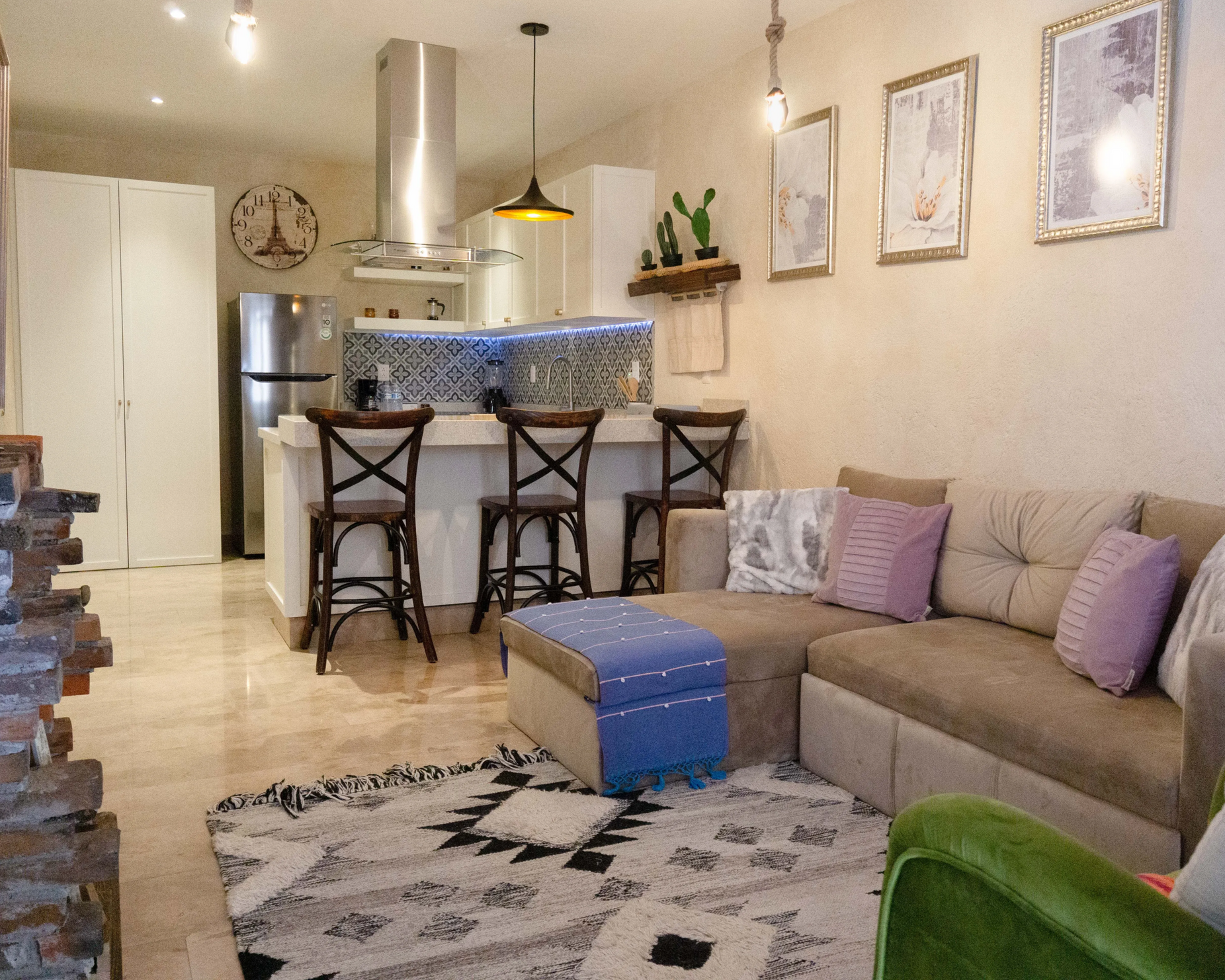 Cozy living room with a sectional sofa, kitchen bar, and decorative rug.