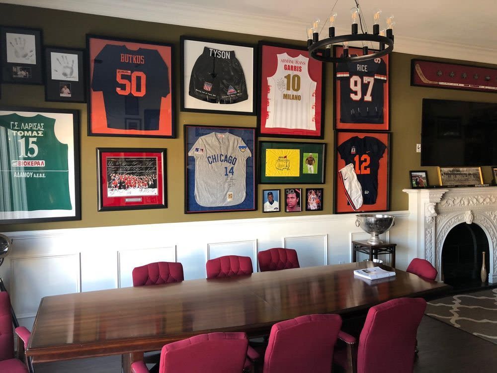 A room with a table and chairs and jerseys on the wall