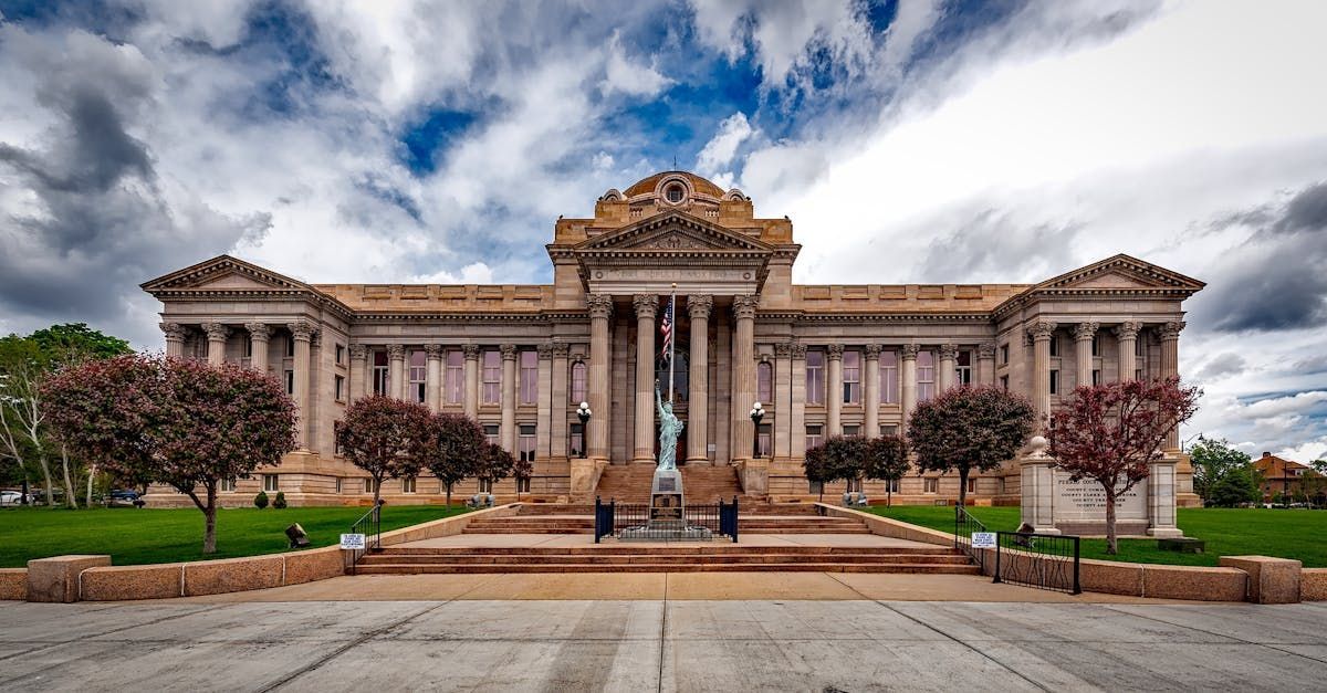 A large building with columns and a statue in front of it.