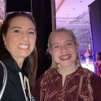 Two women are posing for a picture together in a room.