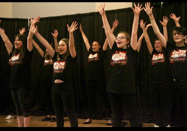 A group of young girls wearing black shirts with the word style on them
