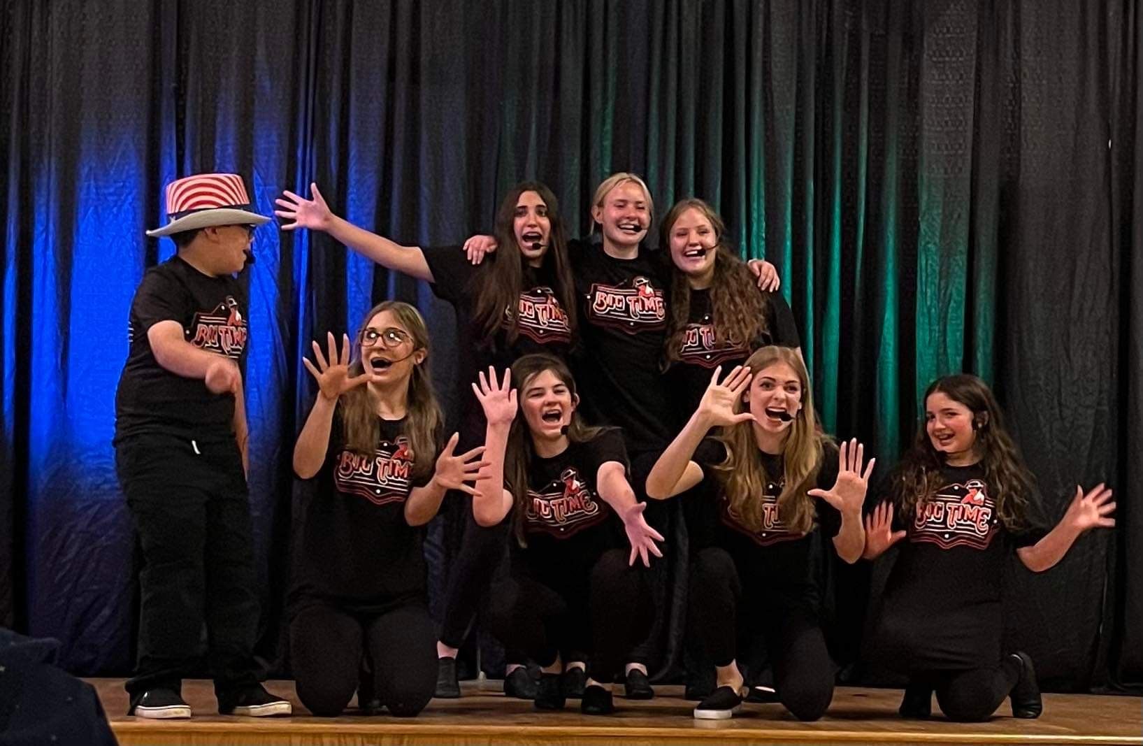 A group of young people are posing for a picture on a stage.