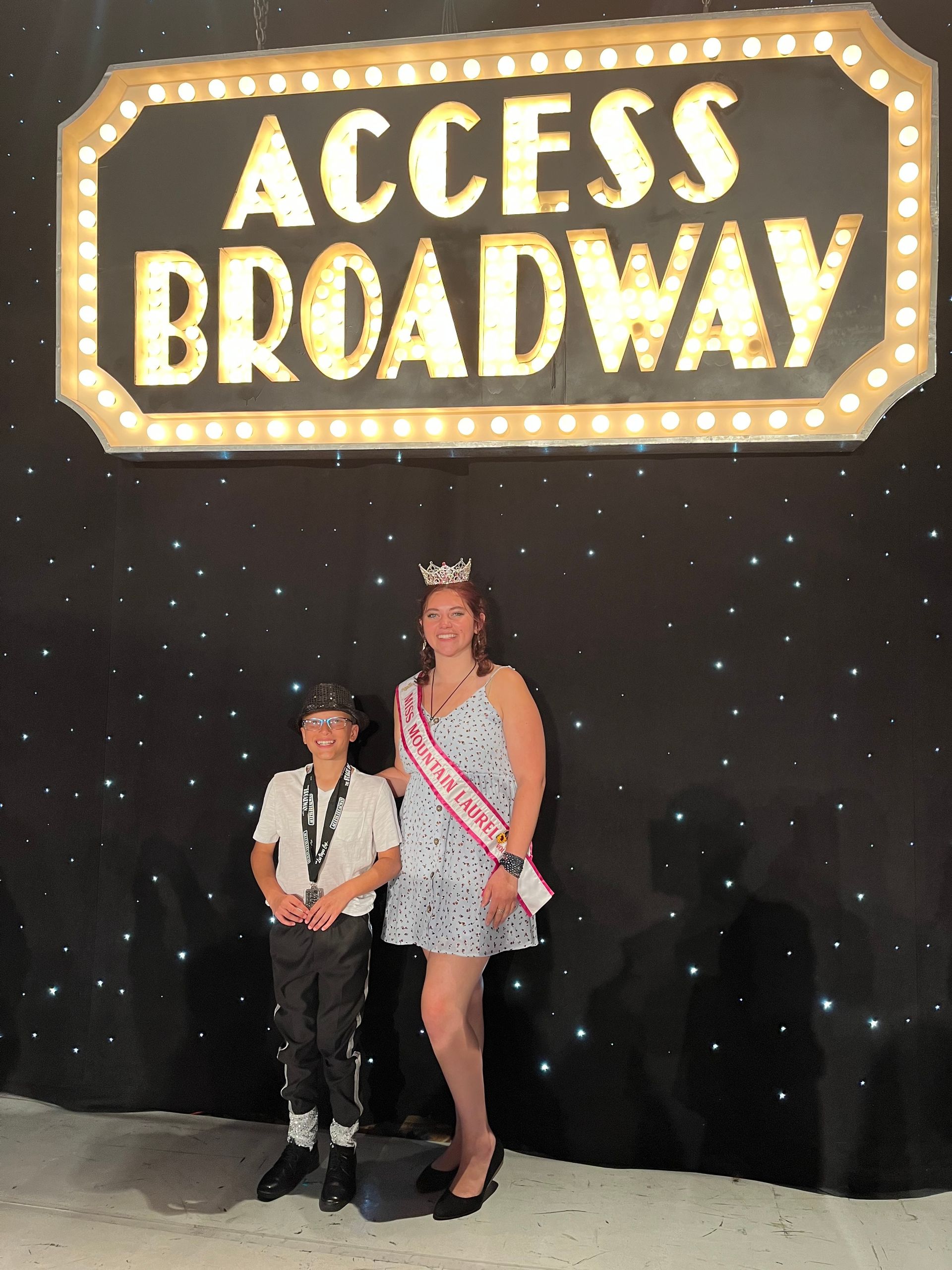 Two people standing in front of a sign that says access broadway