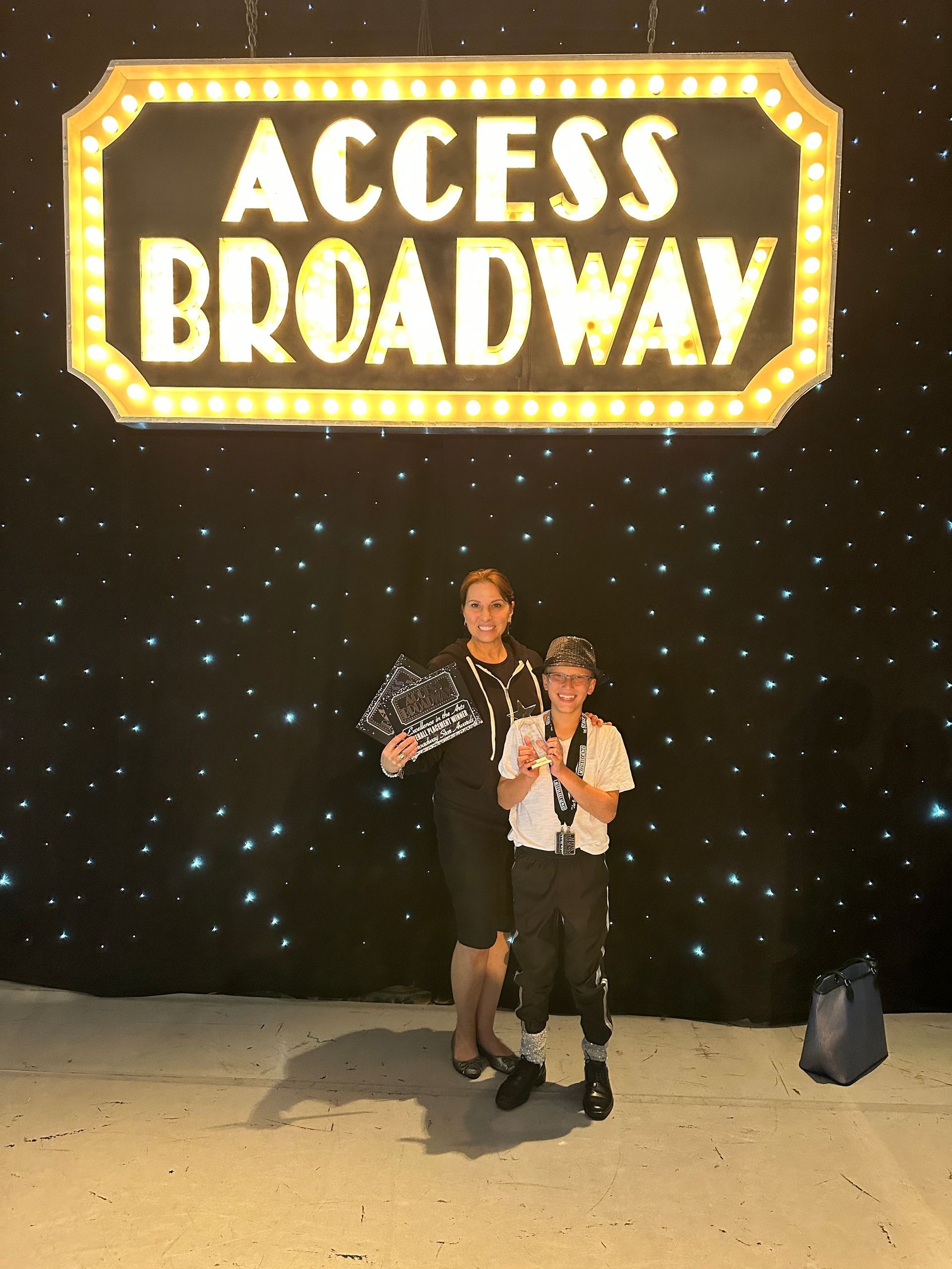 Two people standing in front of a sign that says access broadway