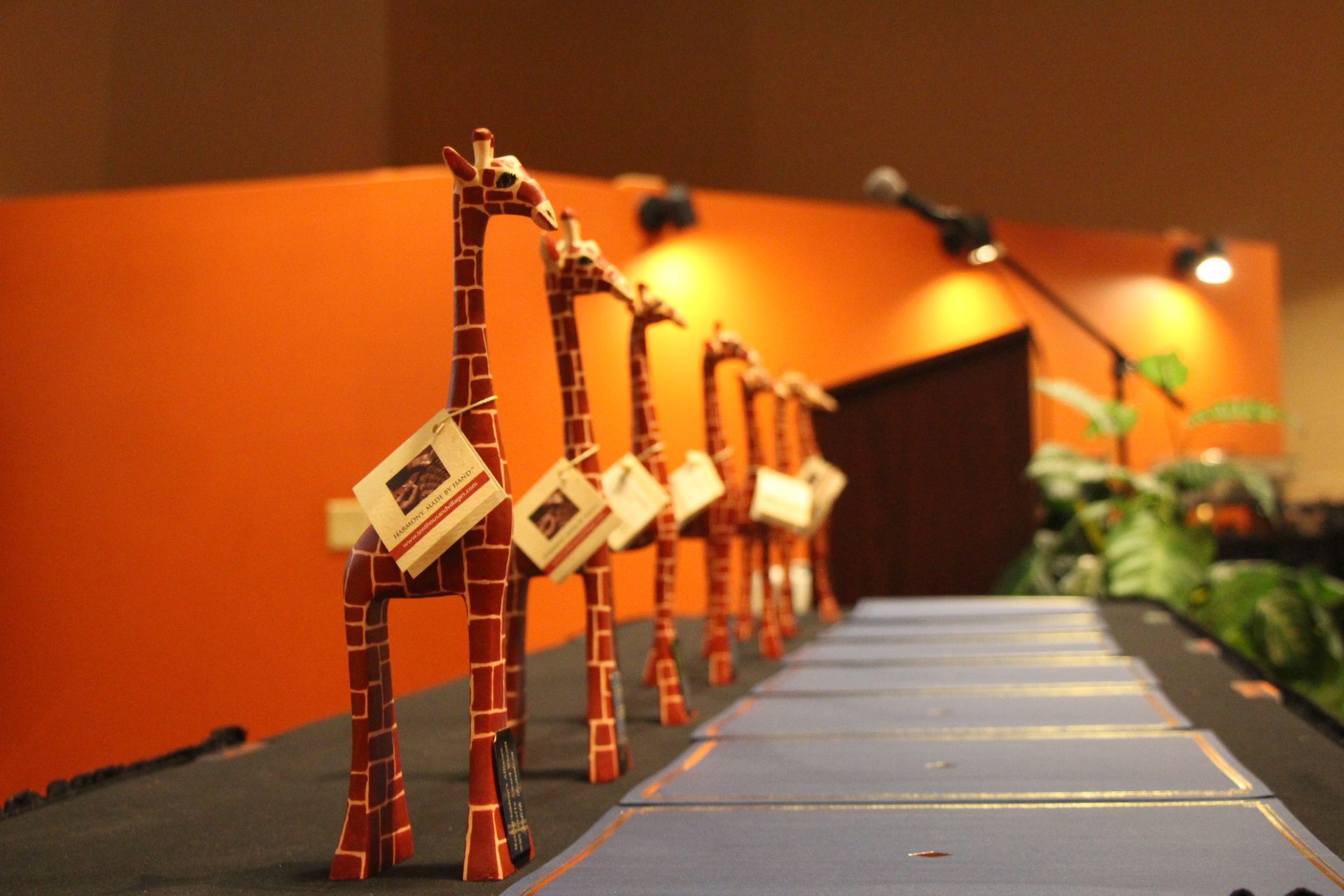 A row of giraffe trophies are lined up on a table