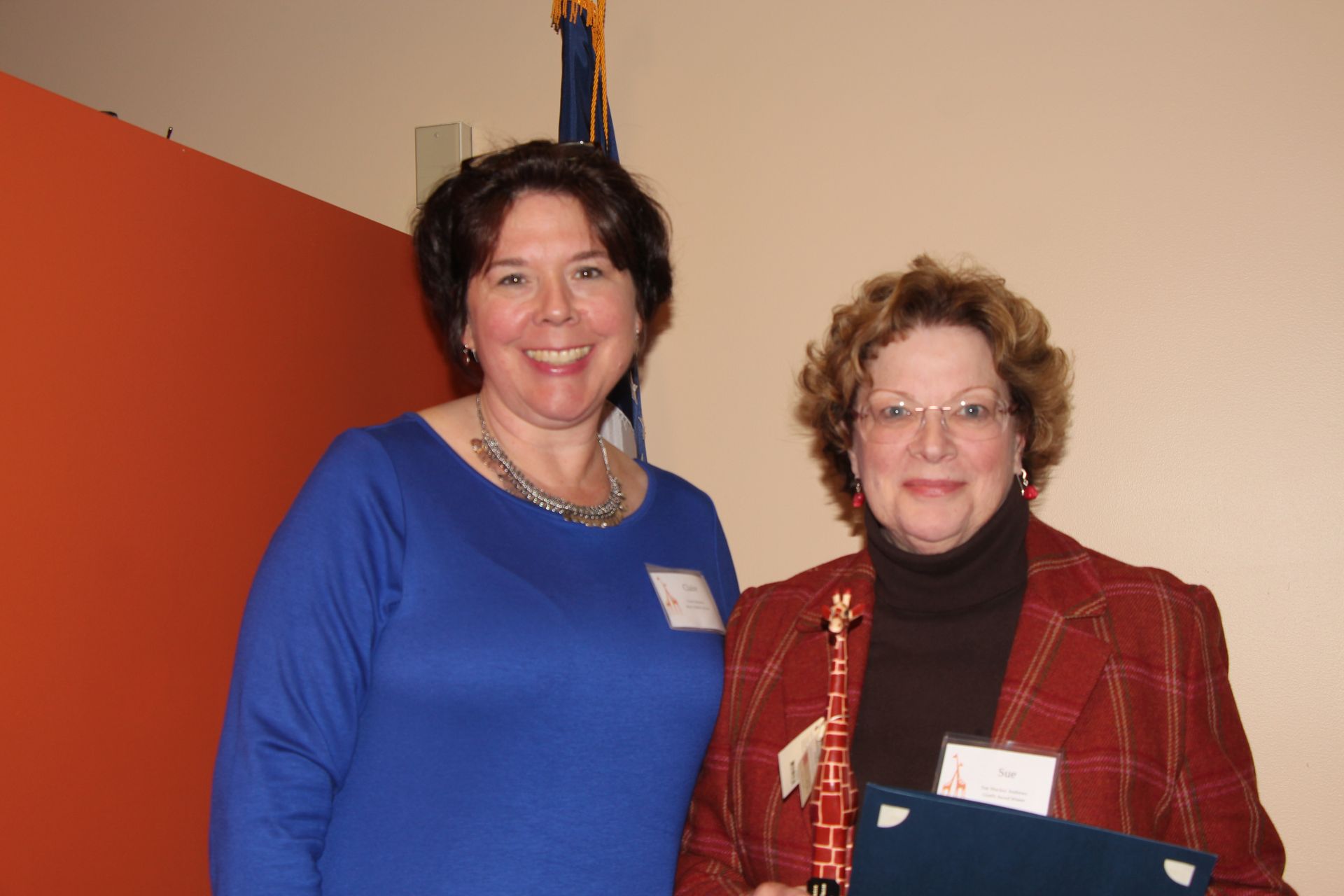 Two women are standing next to each other and smiling