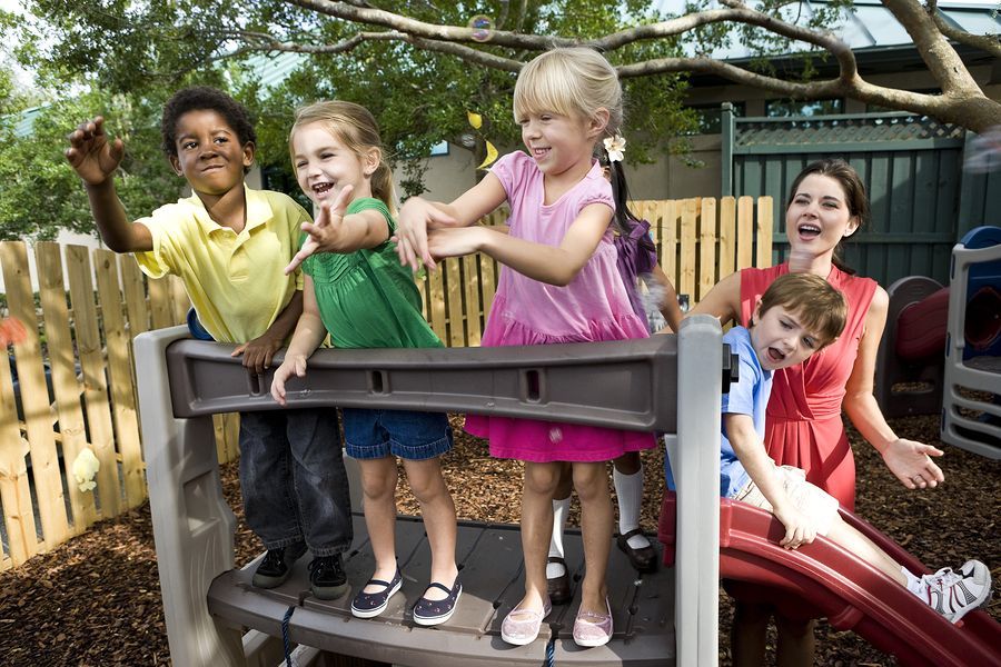 A group of children are playing on a slide at a playground.