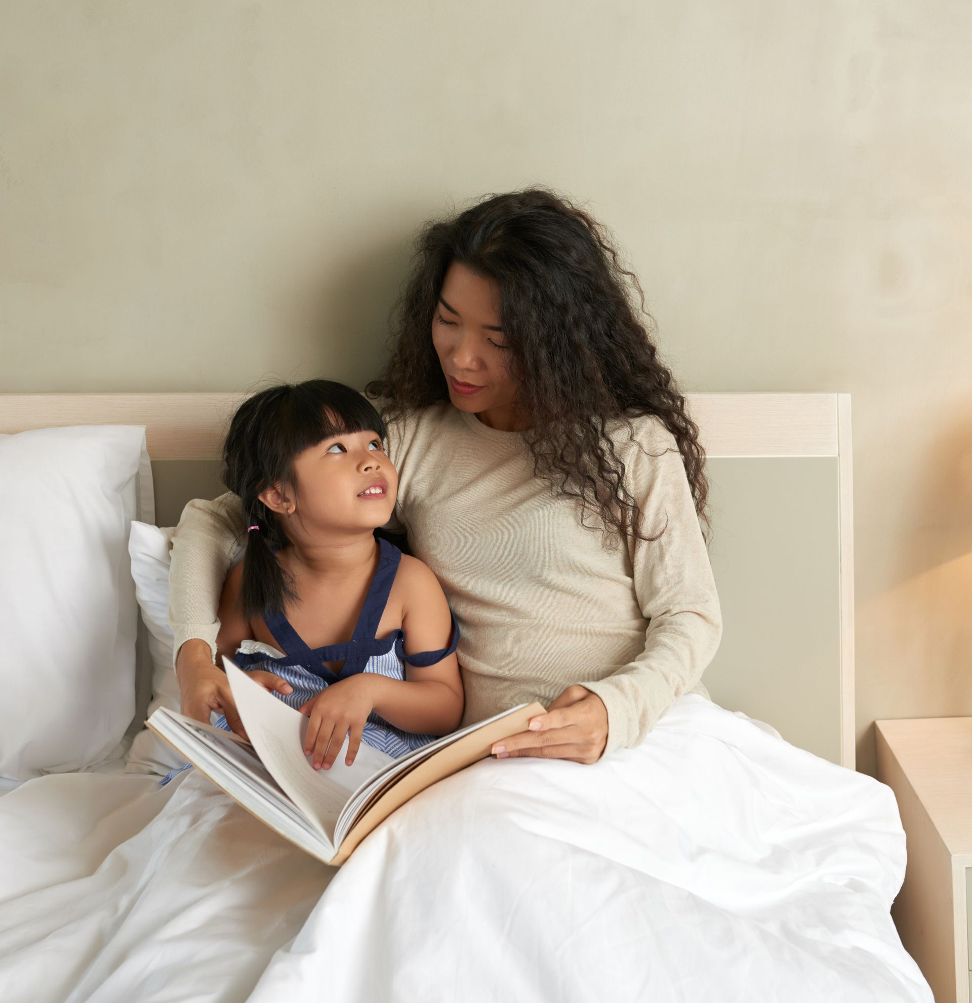Three little girls are sitting on a couch with a baby.