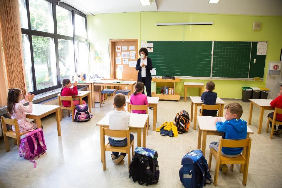 A teacher is teaching a group of children in a classroom.