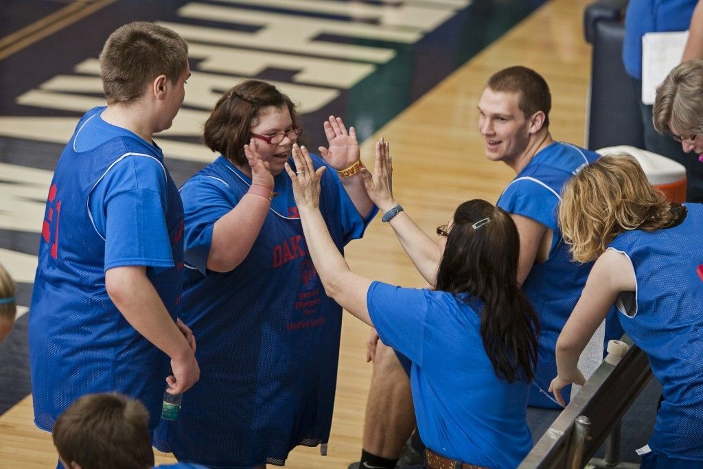 A group of people in blue shirts are giving each other a high five